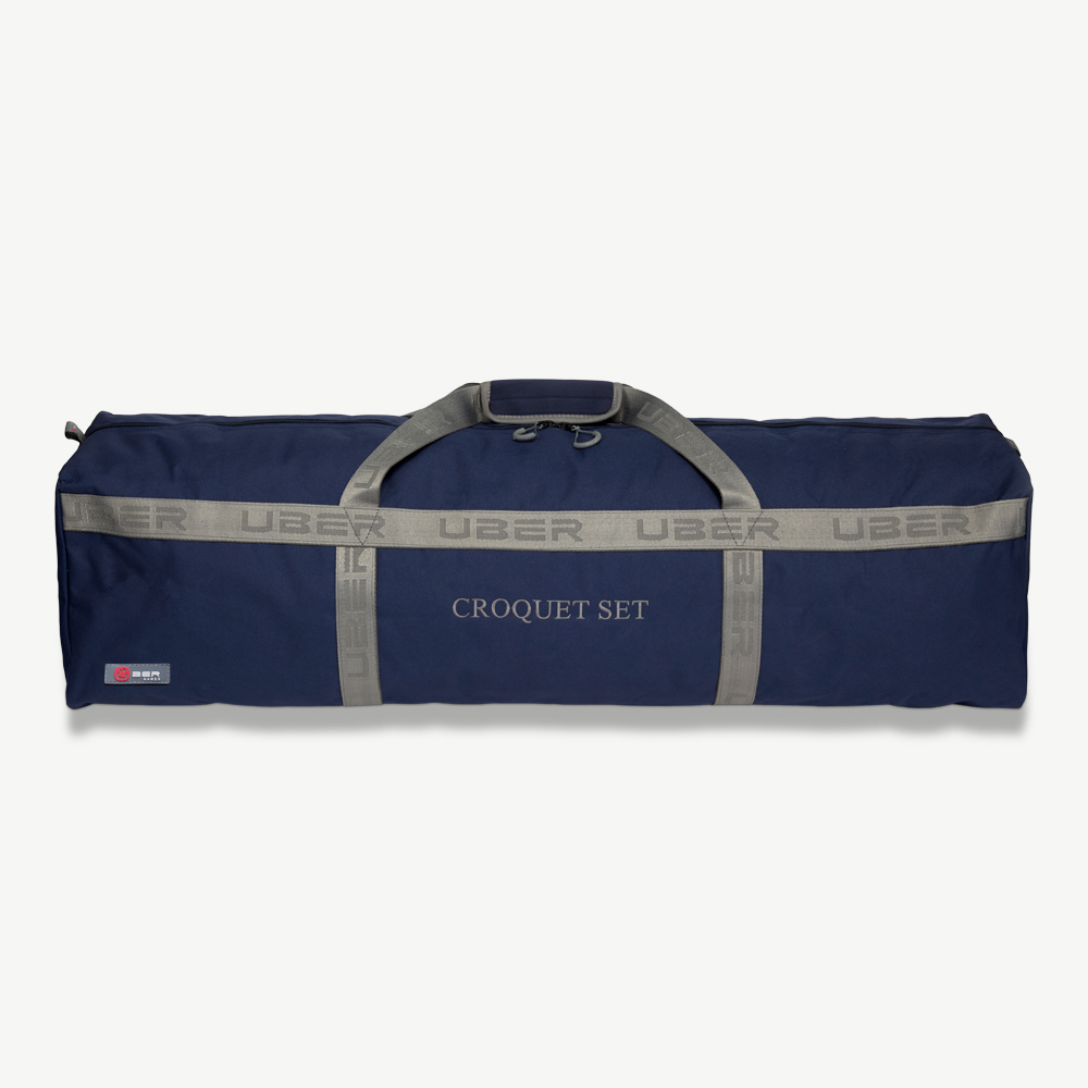 Marineblaue Krocket-Tasche. Text 'UBER' wiederholt sich auf einem grauen Gurtband. Weißer Hintergrund.