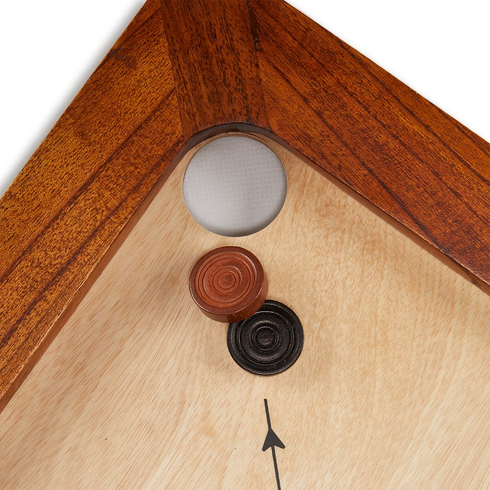 Nahaufnahme einer Carrom-Brett-Ecke mit Spielsteinen.