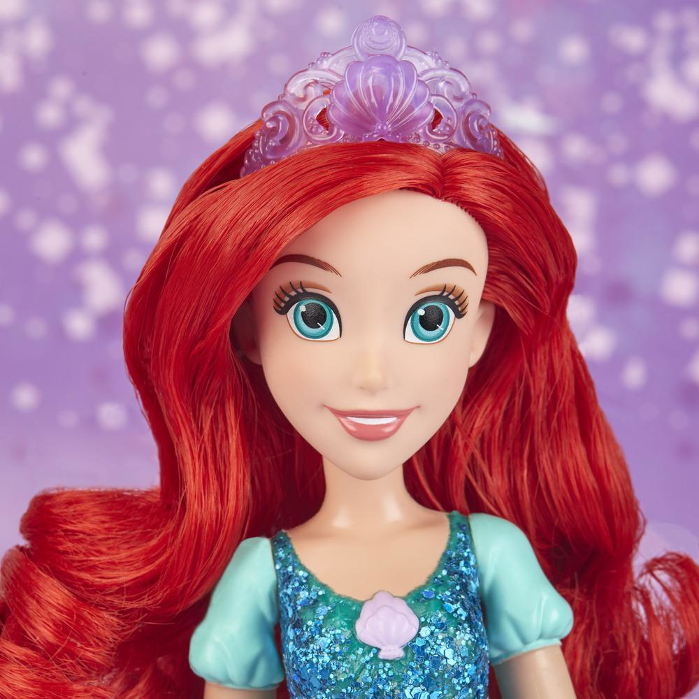 Bambola Ariel con capelli rossi, vestito blu e corona. Sfondo viola.