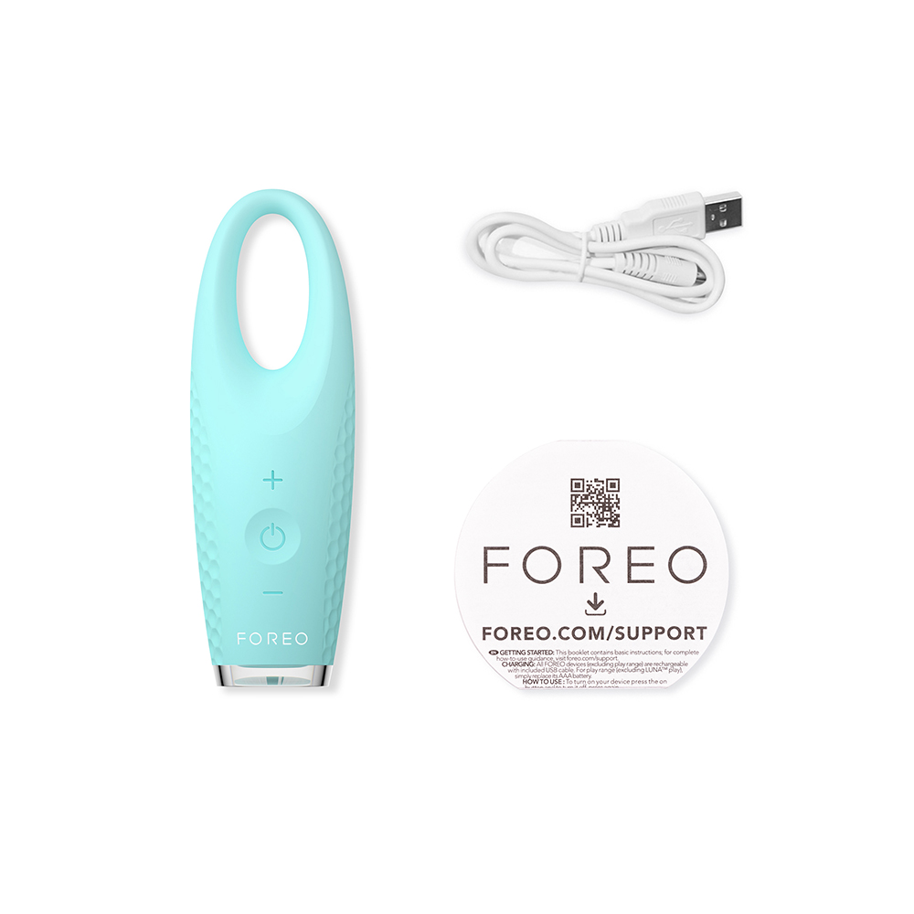 A Foreo device with a USB cable and a support card, all on a white background.