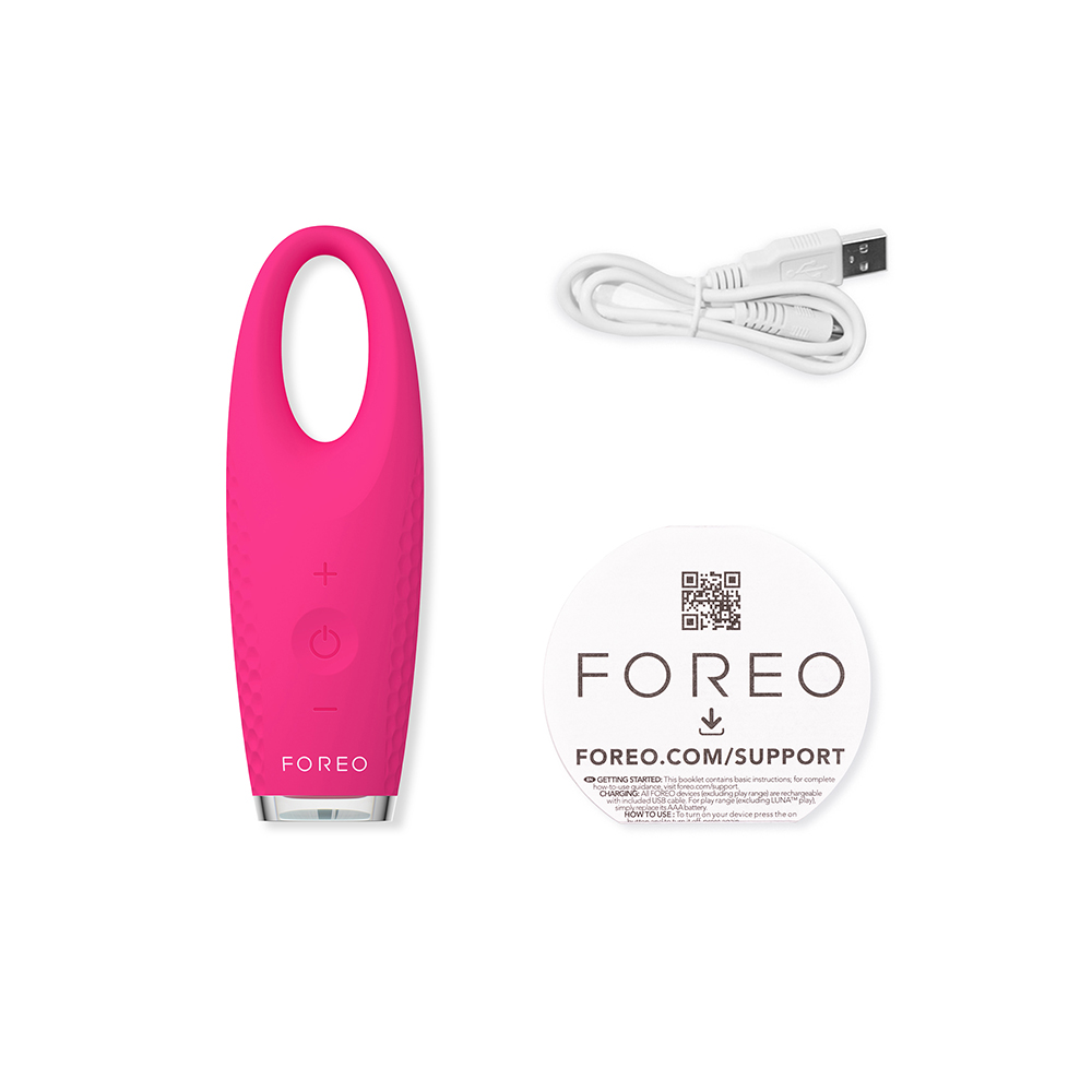 Un appareil Foreo rose avec un câble USB et une carte de support, le tout sur fond blanc.