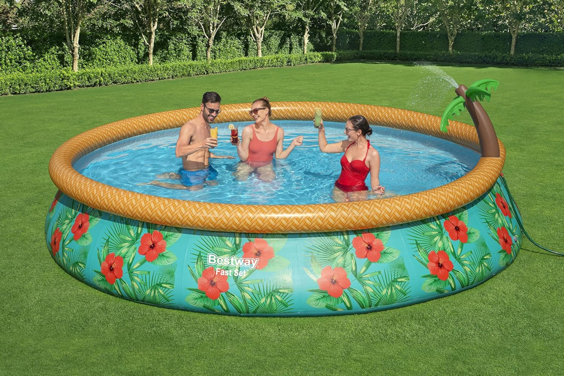 Gruppe von Leuten in einem runden Pool. Der Pool hat ein tropisches Thema mit Palmen-Wasserspiel.
