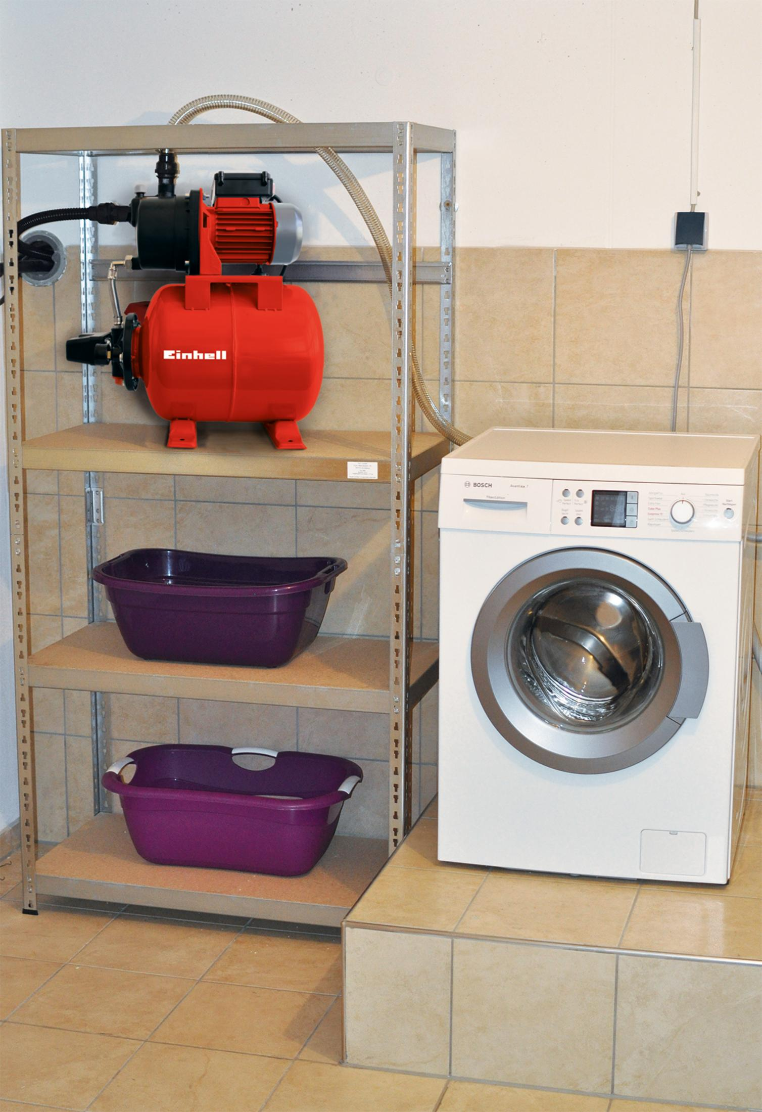 Bomba de agua roja Einhell en estante con dos cubos morados y una lavadora.