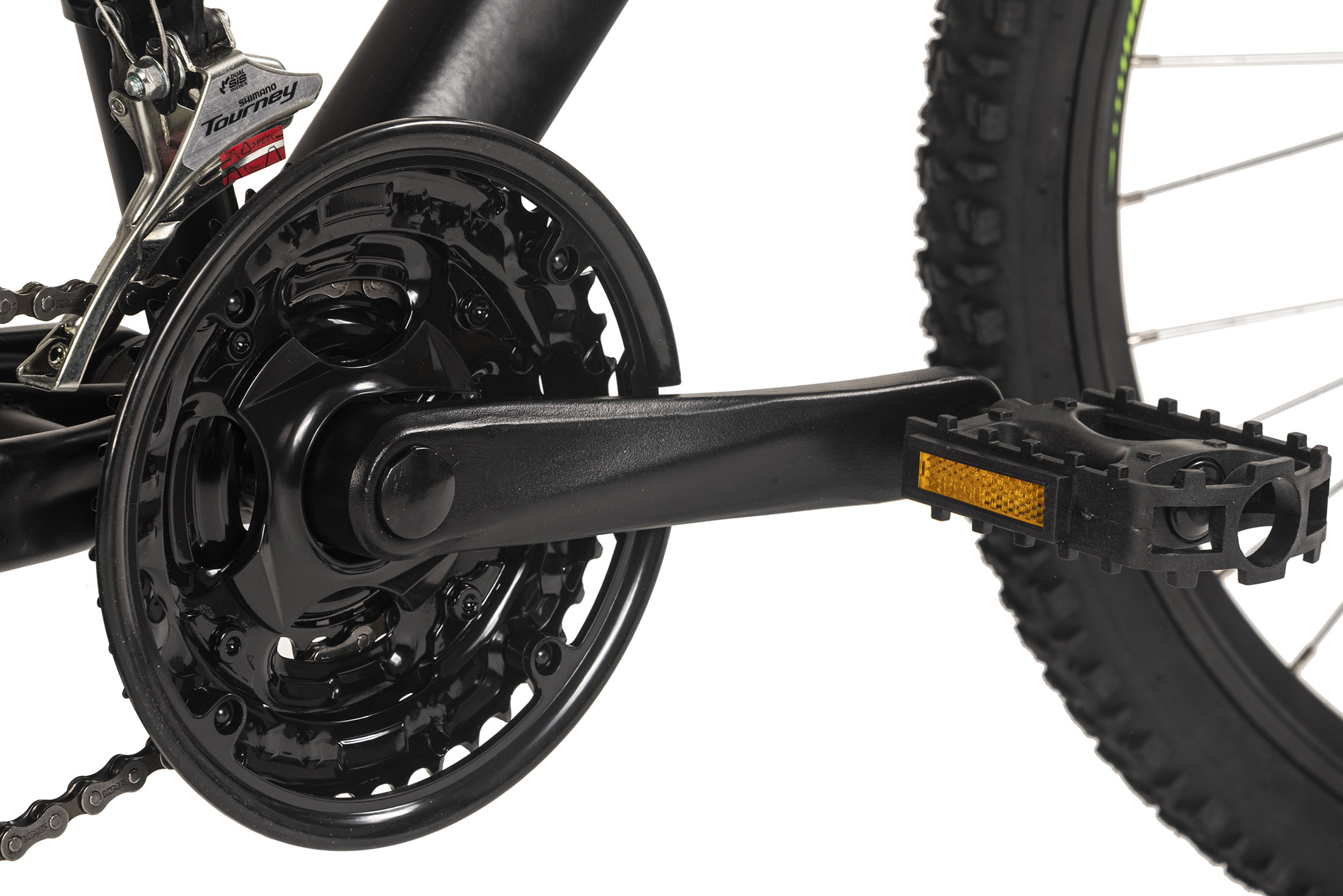 Nahaufnahme von Kette, Kurbel und Pedal eines Fahrrads. Schwarze Komponenten mit Reflektor am Pedal.