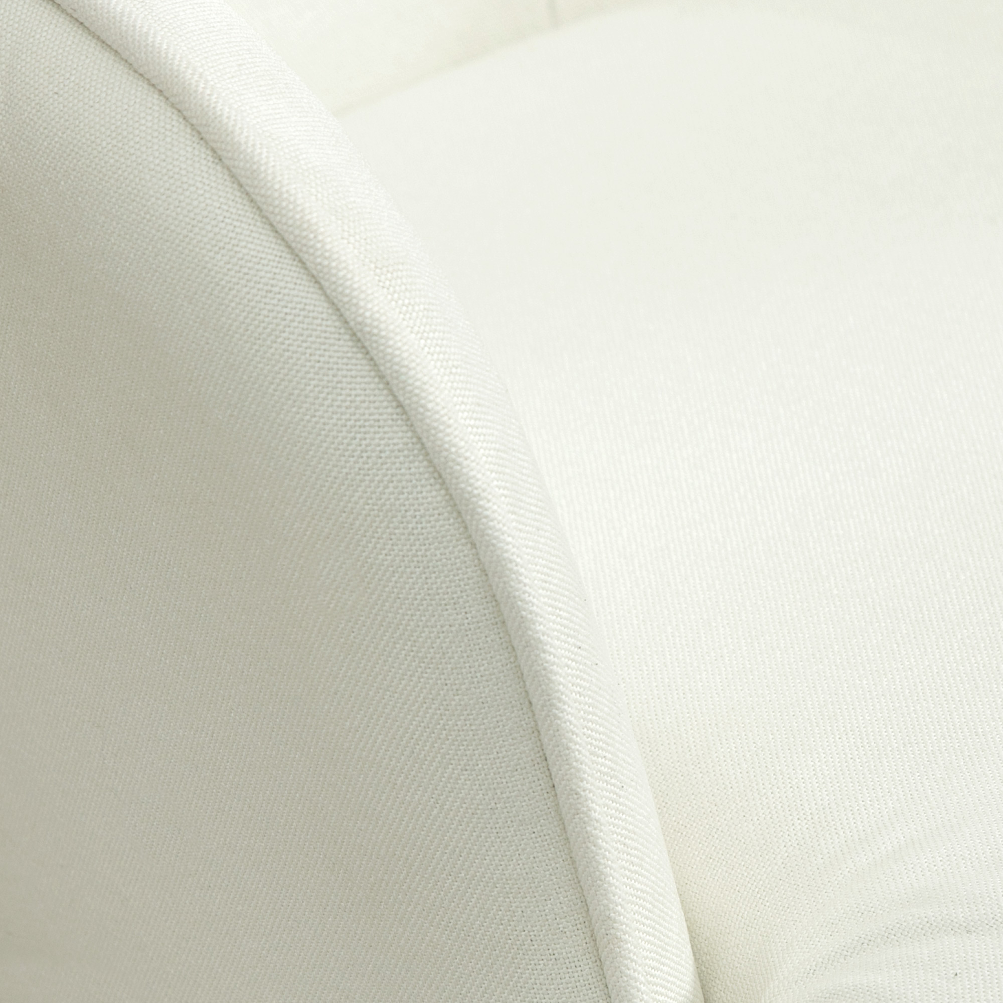 Primer plano del respaldo curvo blanco de una silla con textura de tela.