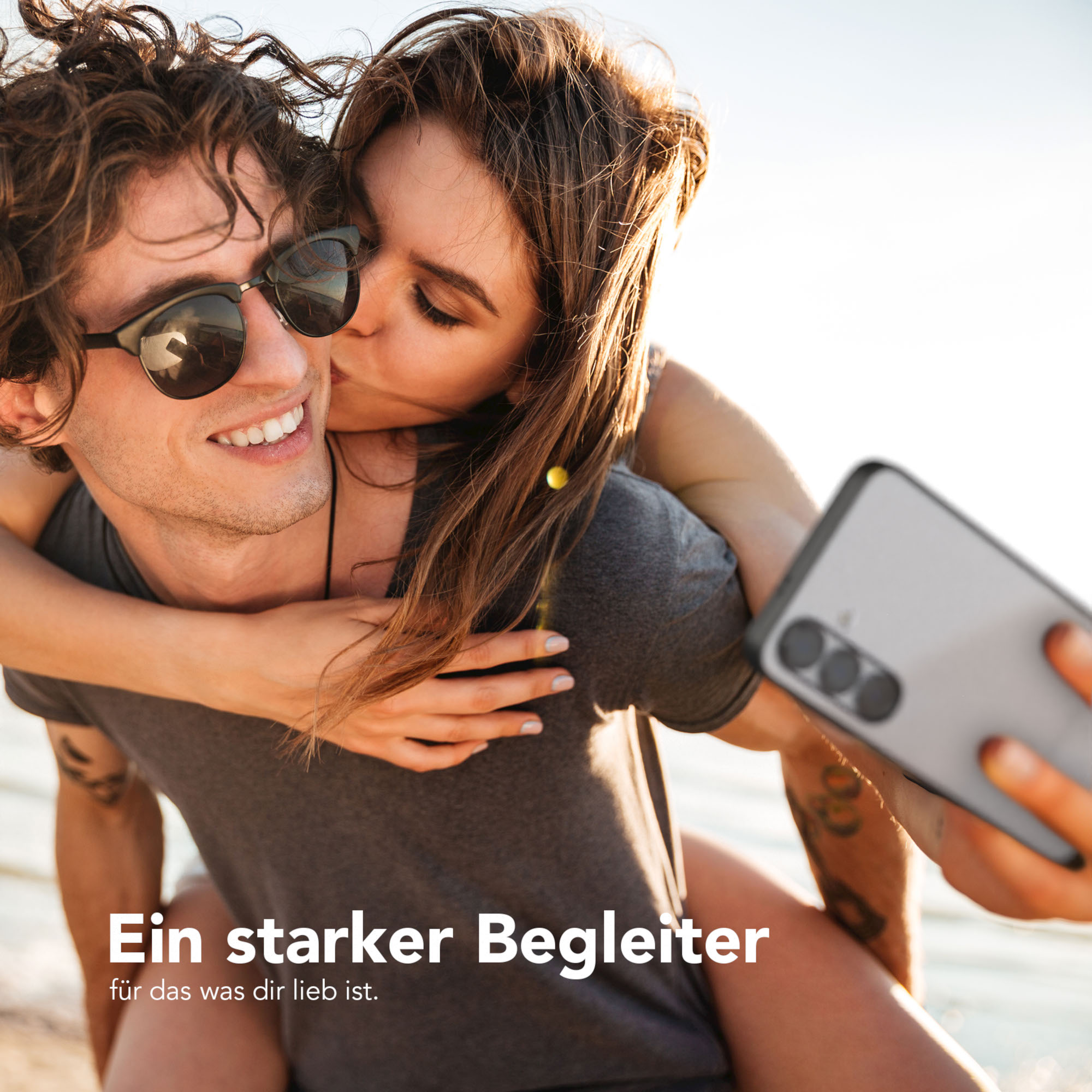 Ein Paar macht ein Selfie. Die Frau küsst den Mann auf die Wange. Text: 'Ein starker Begleiter'.