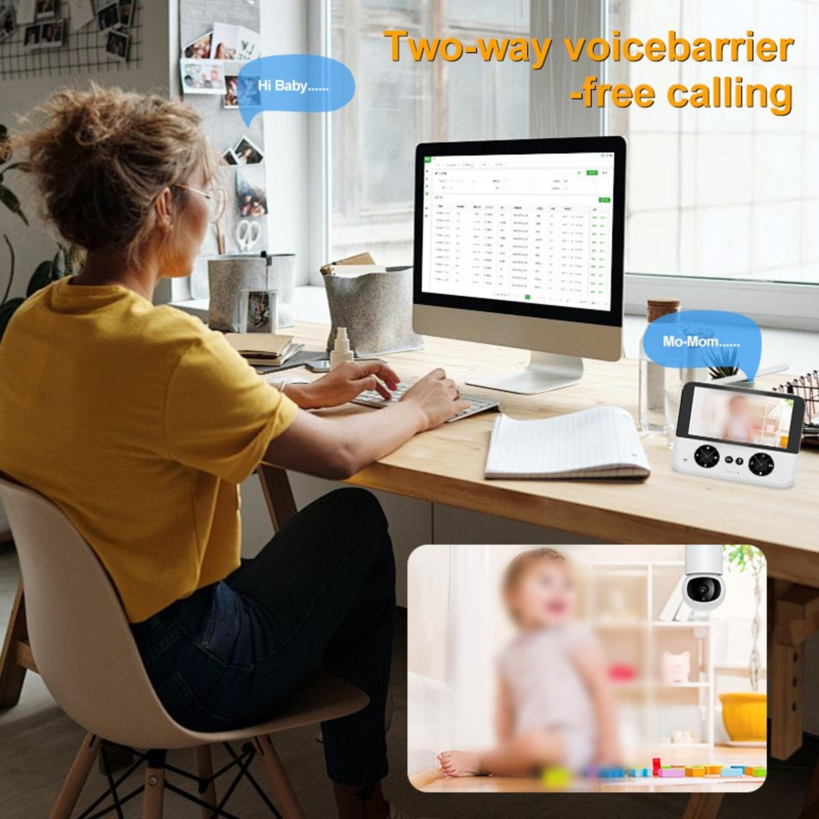 Eine Frau arbeitet am Computer, mit einem Babyphone, das ein unscharfes Bild zeigt.