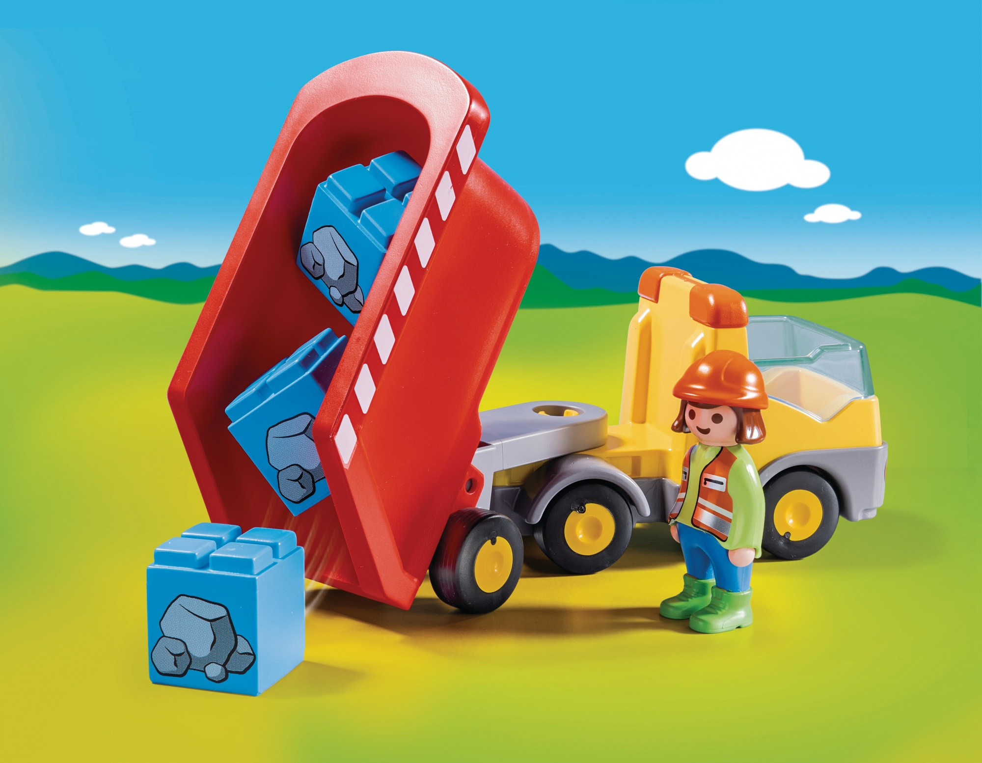 Ein Spielzeug-LKW mit blauen Blöcken und einem Bauarbeiter.