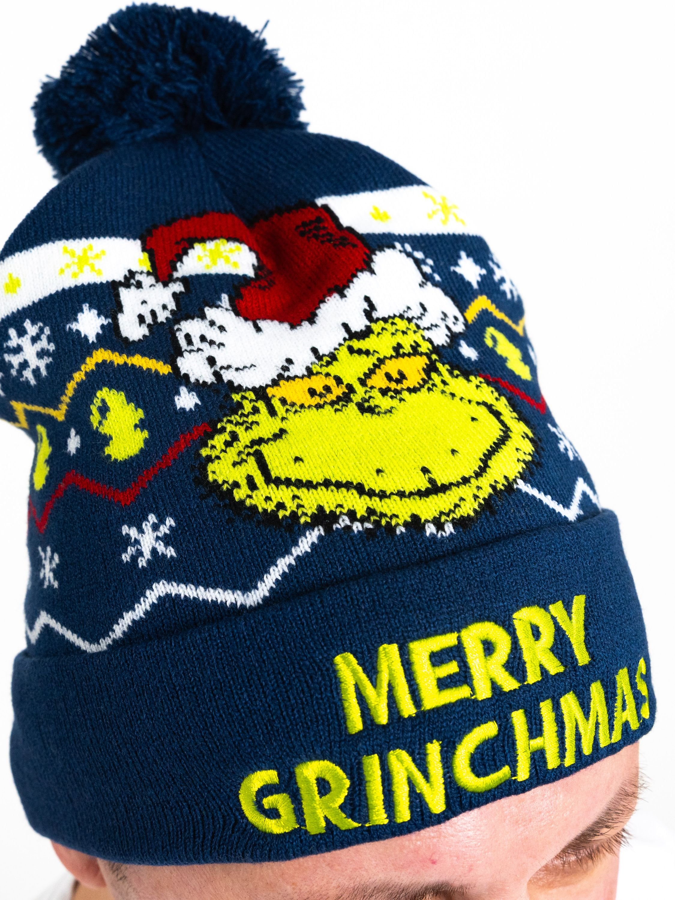 Marineblaue Strick-Grinch-Mütze mit Grinch-Gesicht und 'Merry Grinchmas'-Text.