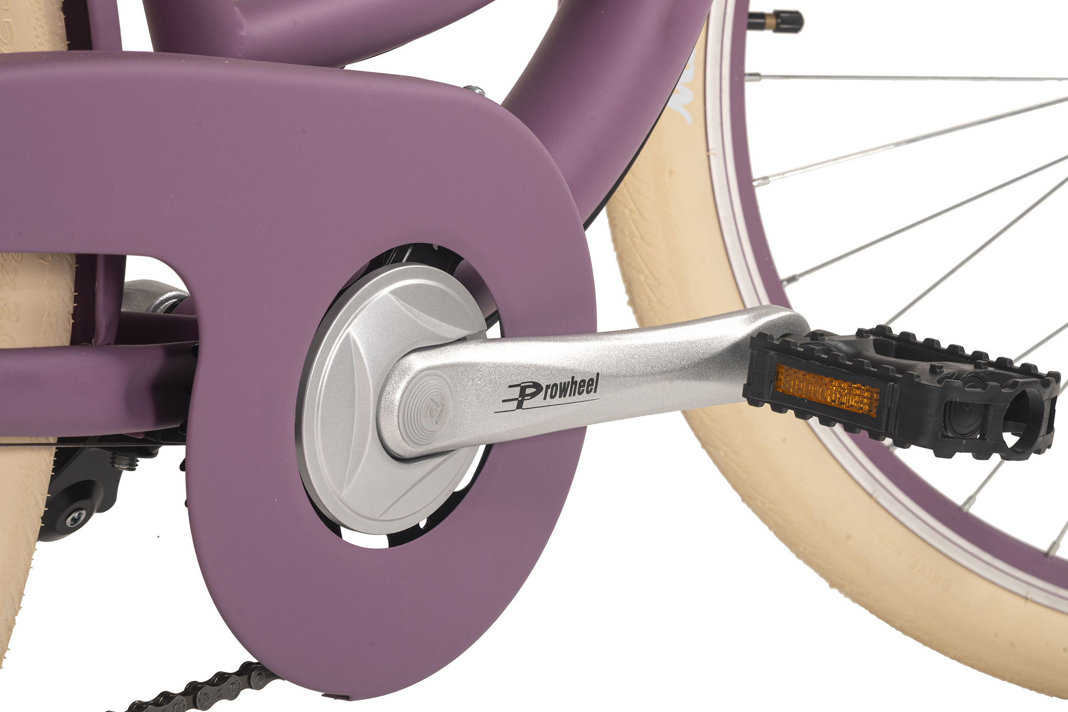 Nahaufnahme von Fahrradpedal, Kurbel und Kettenschutz, lila Fahrrad mit cremefarbenem Reifen, weißer Hintergrund.