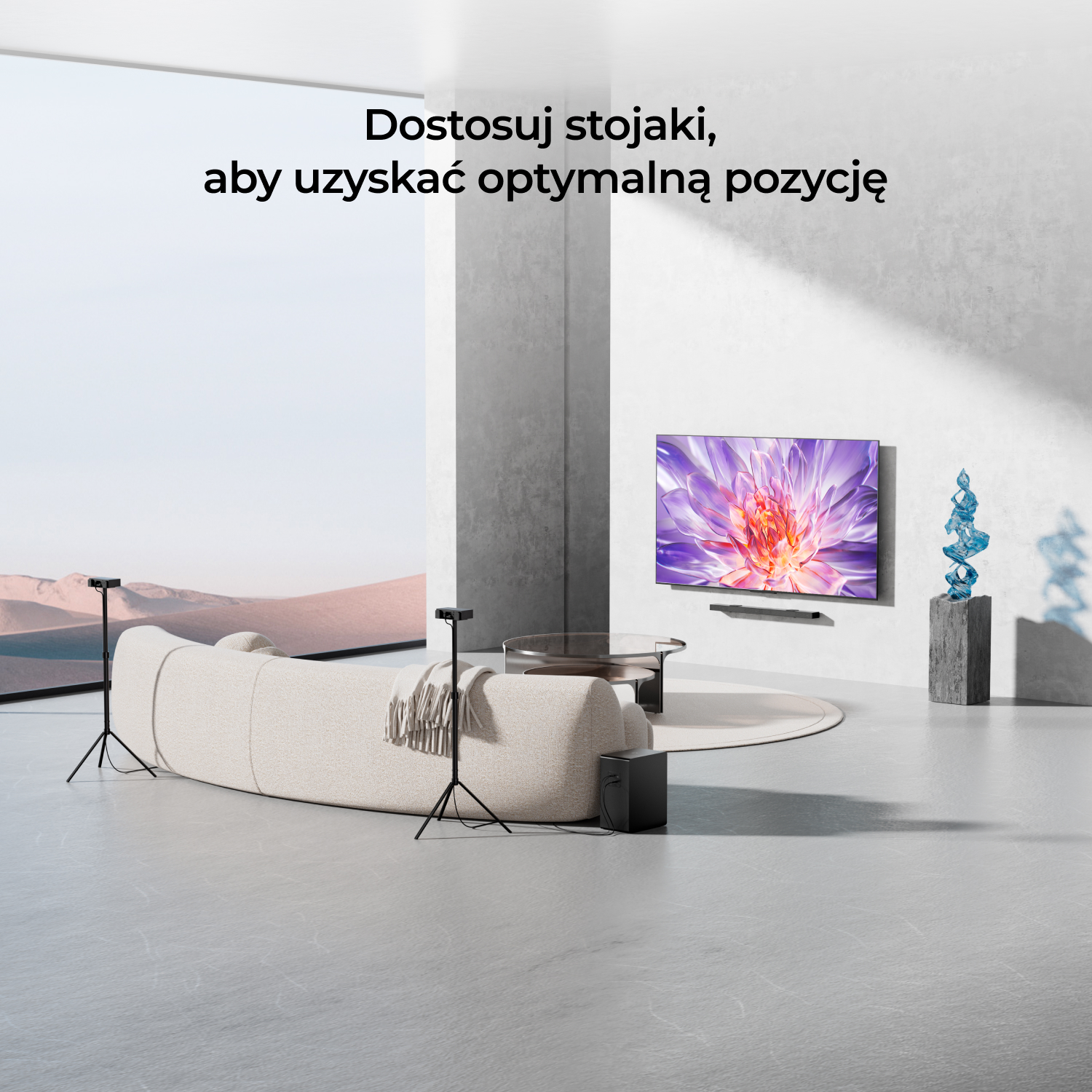 Pokój z telewizorem, głośnikami na stojakach, sofą i elementami dekoracyjnymi.