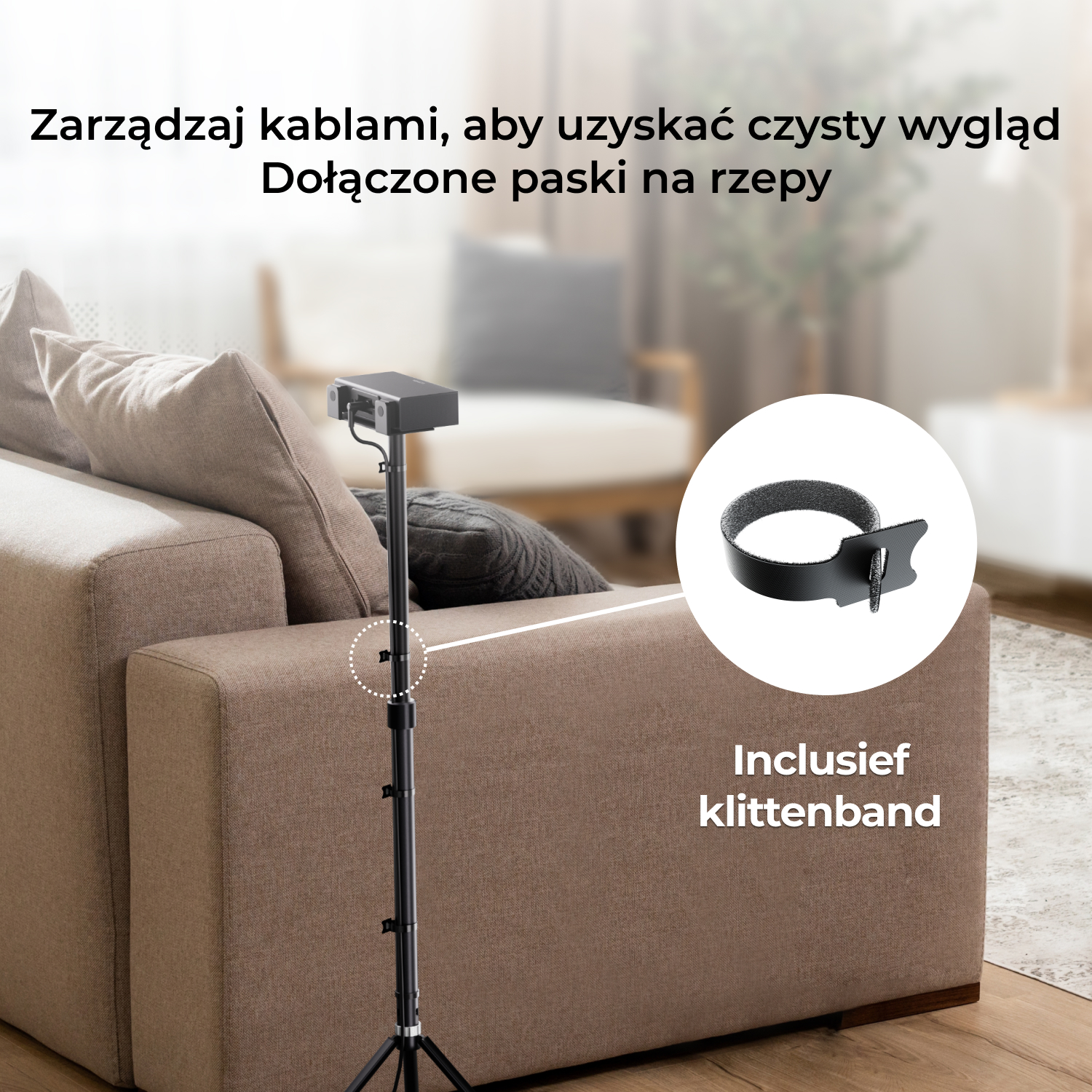 Głośnik na stojaku z paskiem do zarządzania kablami przymocowanym do boku sofy.