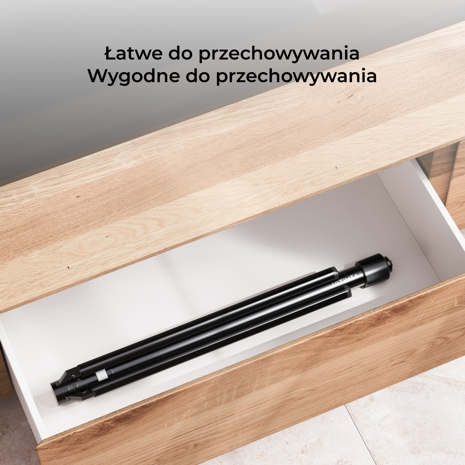 Szuflada z czarnym stojakiem głośnikowym w środku. Szuflada jest otwarta. Szuflada jest w drewnianej szafce.