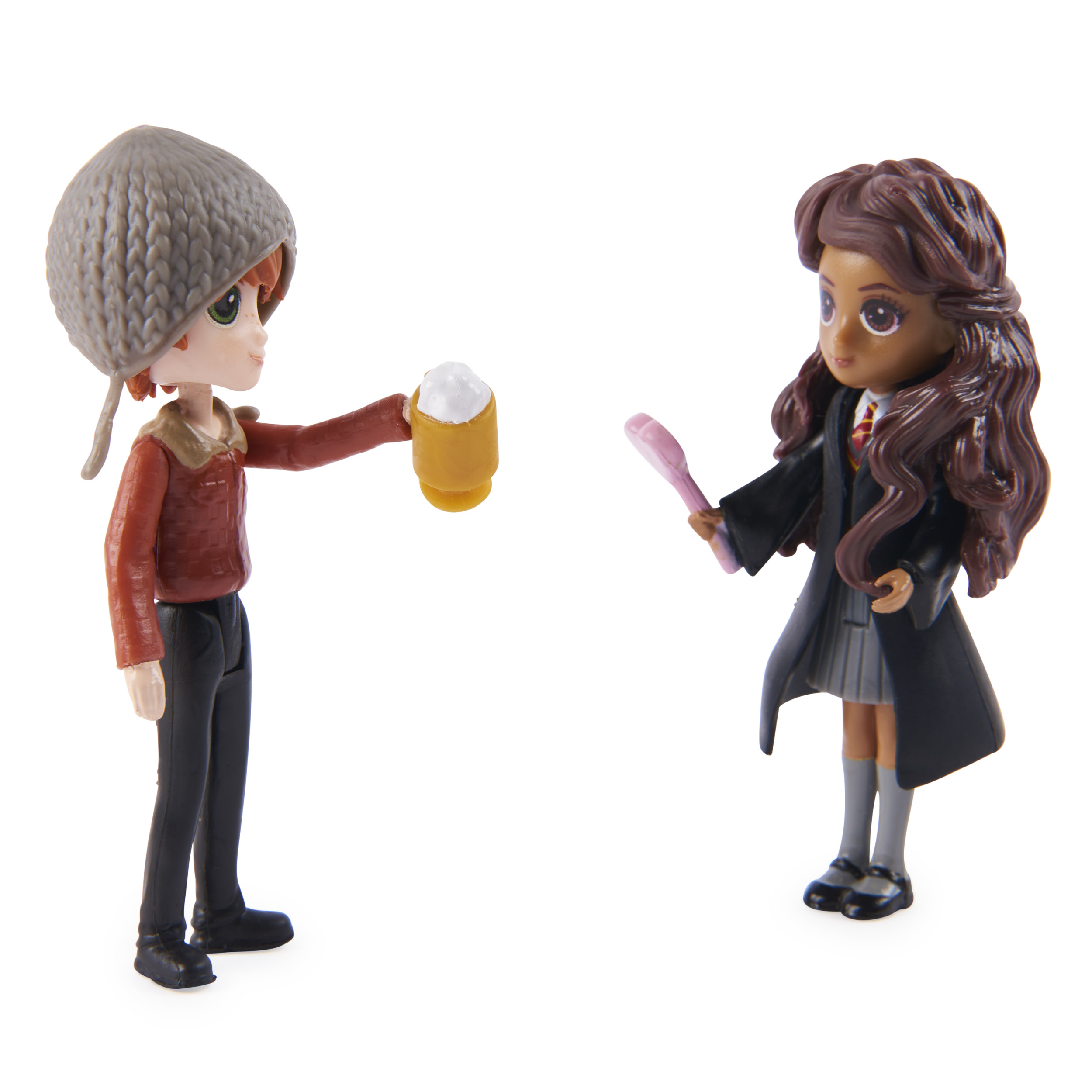 Figurine di Ron e Hermione, uno con una tazza, l'altro con una bacchetta.