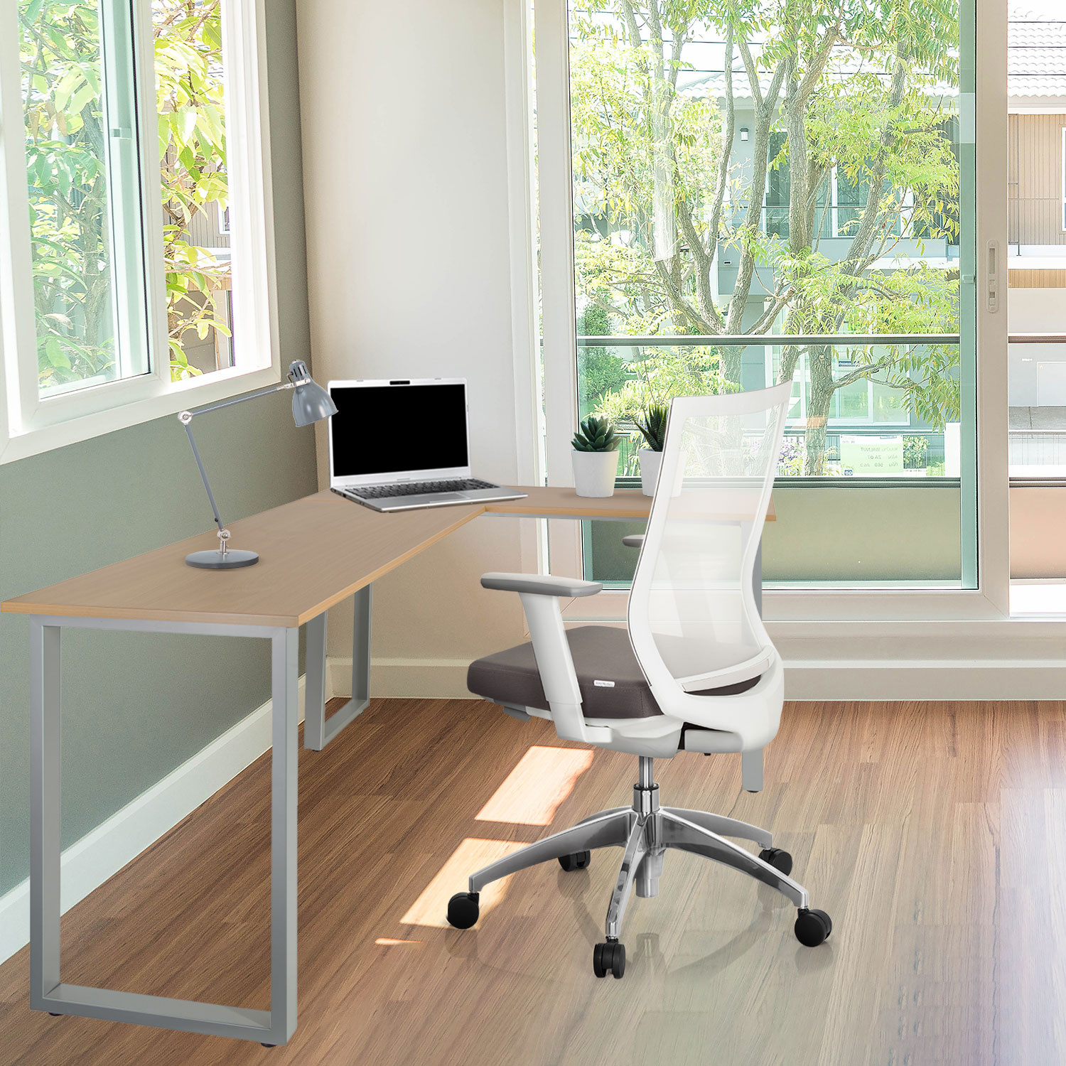 Büro mit L-förmigem Schreibtisch, Laptop und Stuhl. Fenster und Bäume im Hintergrund.