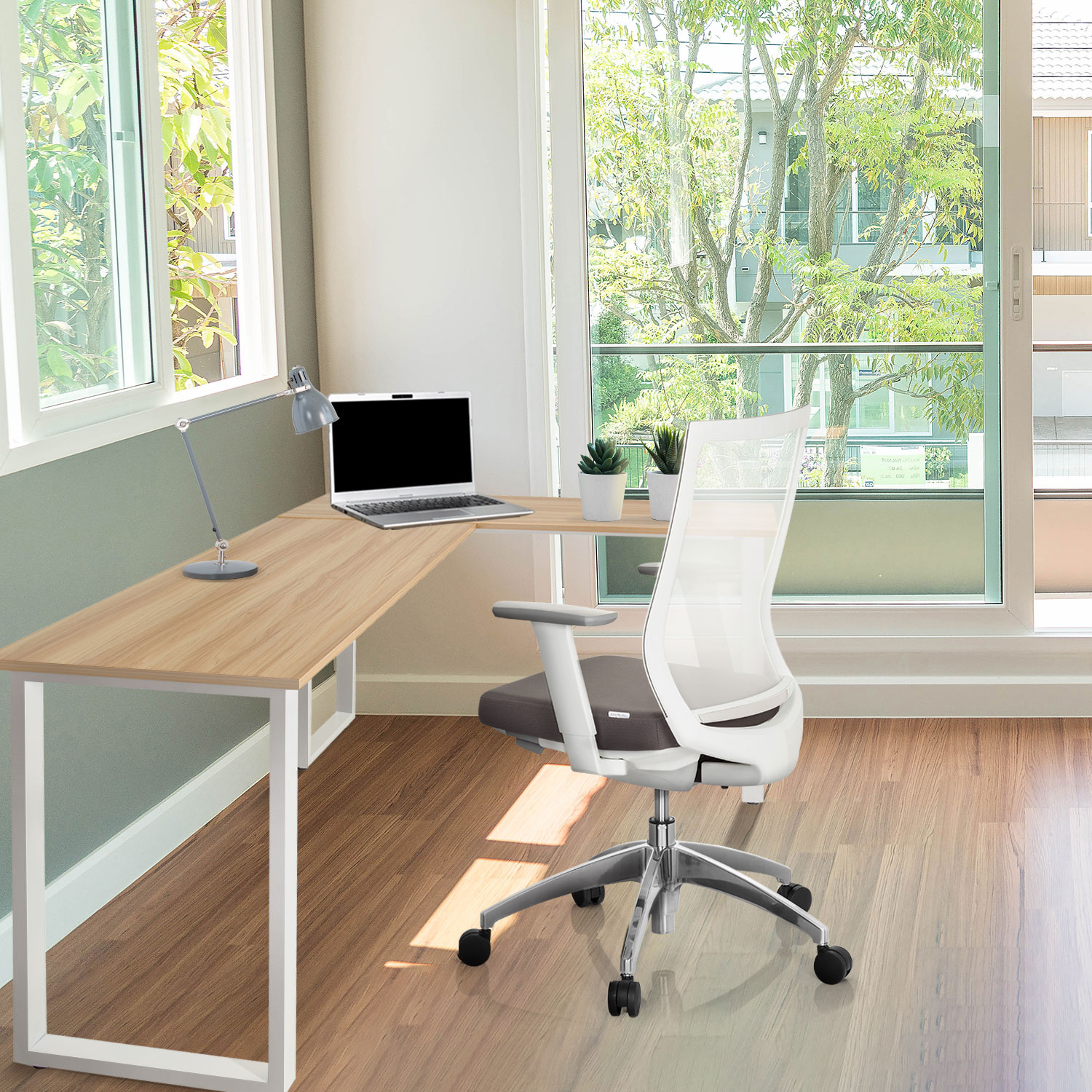 Büro-Setup mit L-förmigem Schreibtisch, Laptop und weißem Netzstuhl. Heller, moderner Raum.
