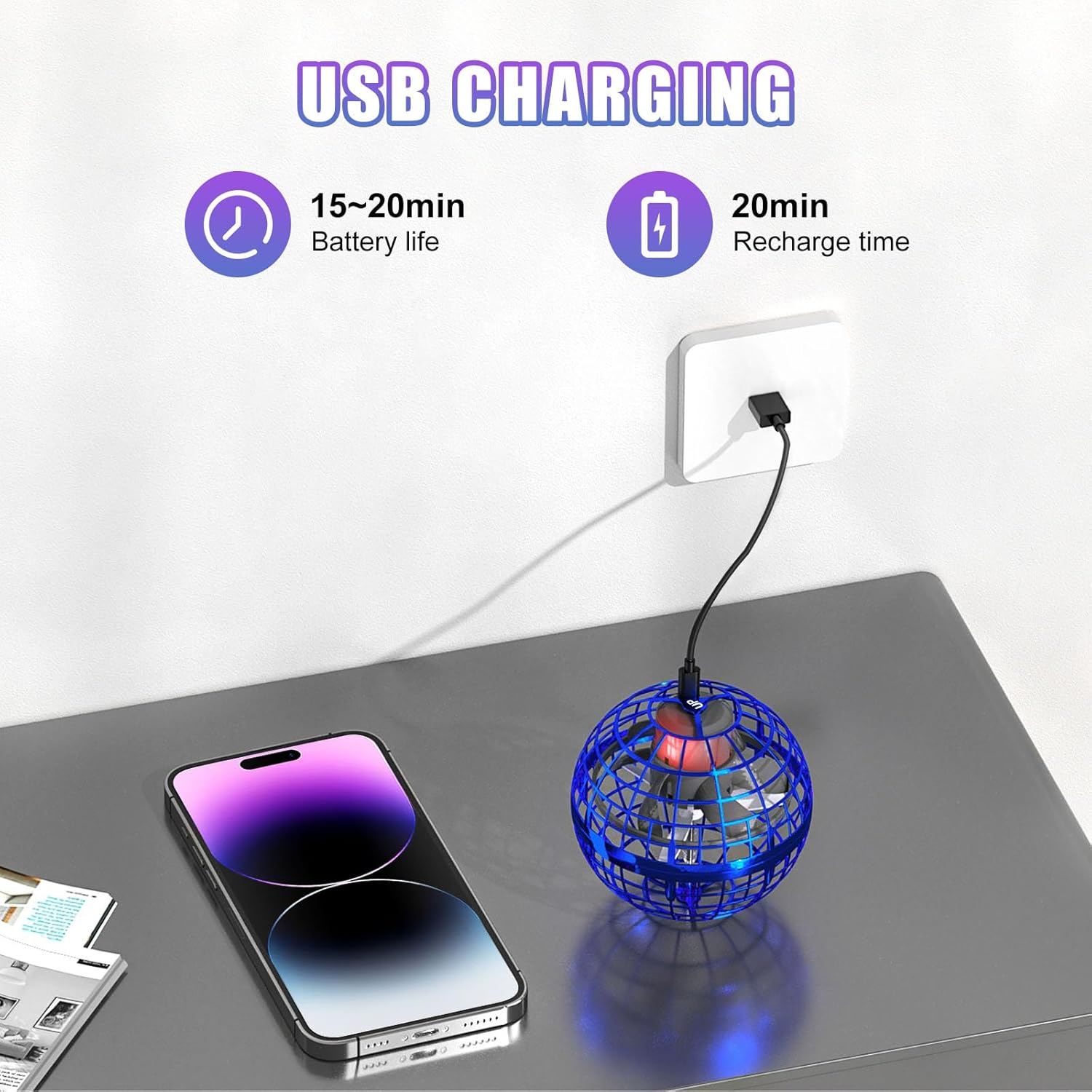 Ein Telefon wird geladen. Ein blaues Orb-Spielzeug befindet sich neben dem Telefon. Text: USB-Aufladung, 15-20min Akkulaufzeit.