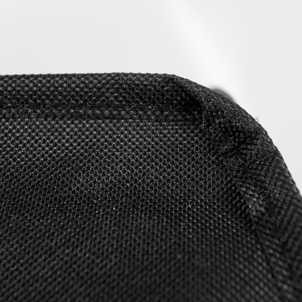 Close-up of black fabric. It has a woven texture and a slight creasing on the surface.