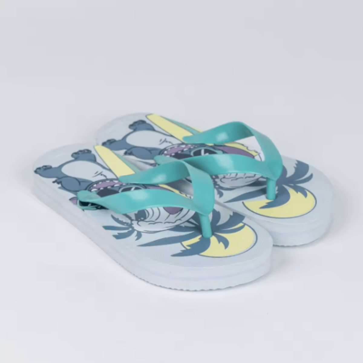 Un par de chanclas Stitch, suelas blancas, correas azules, sobre un fondo blanco.