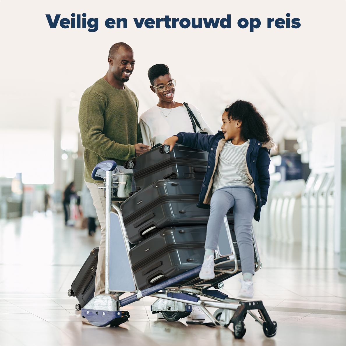 Family at airport with luggage on a cart; happy and smiling.