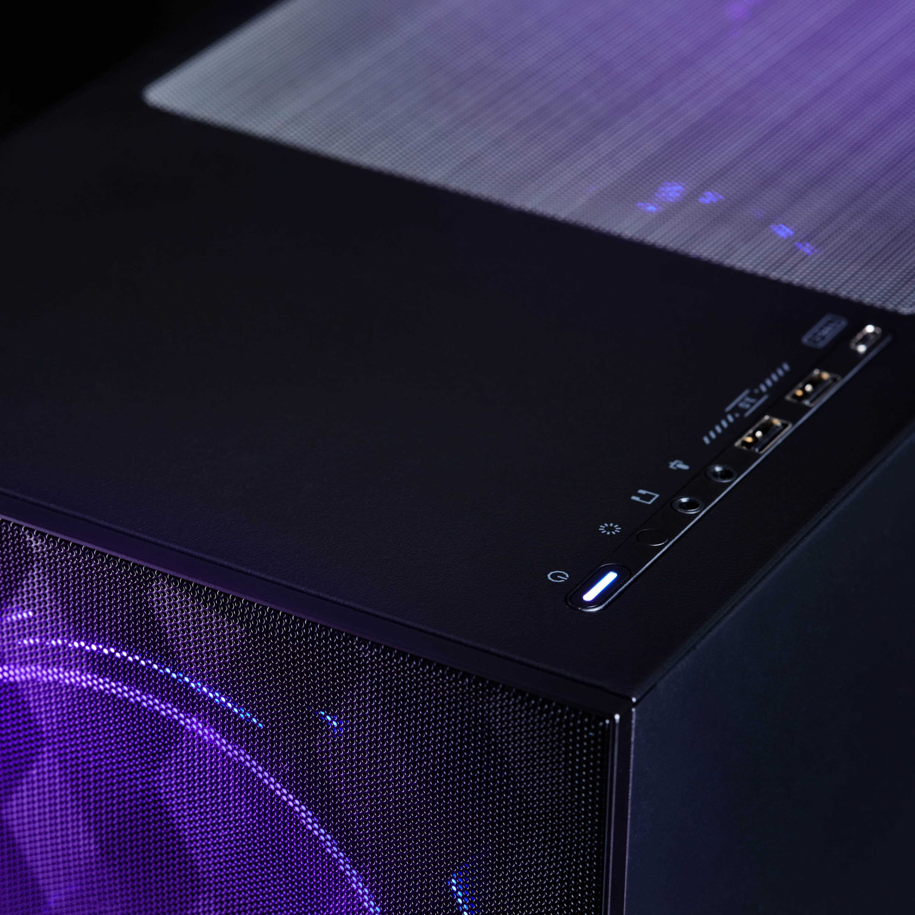 Schwarzes Computergehäuse mit beleuchteter Einschalttaste und einem leuchtenden lila Lüfter im Inneren.