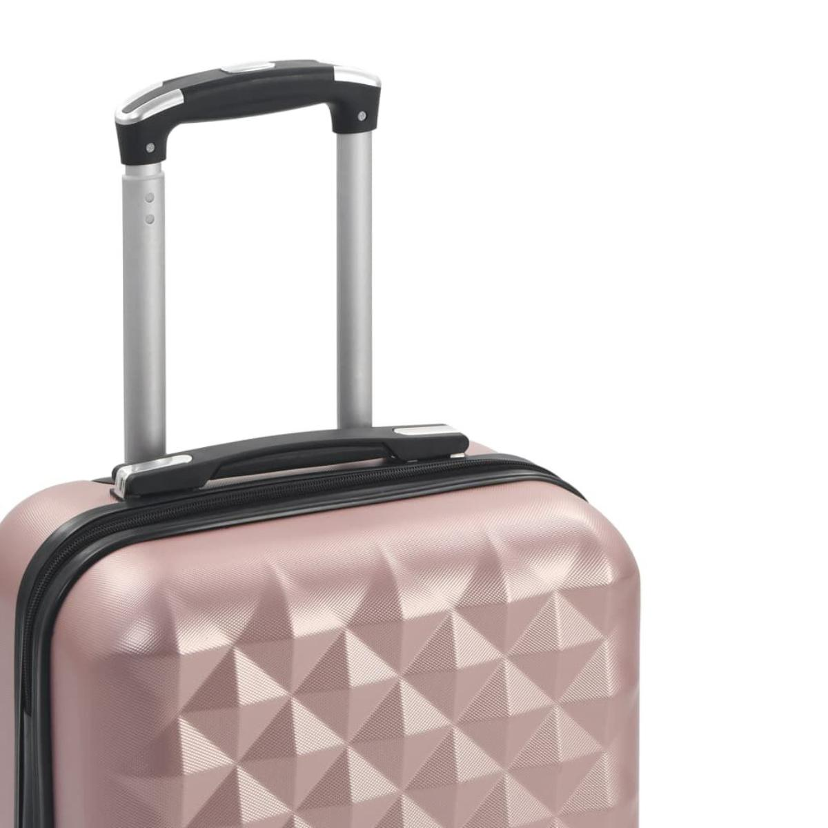 Nahaufnahme eines rosa Reisekoffergriffs und der Oberseite des Koffers mit strukturierter Oberfläche.