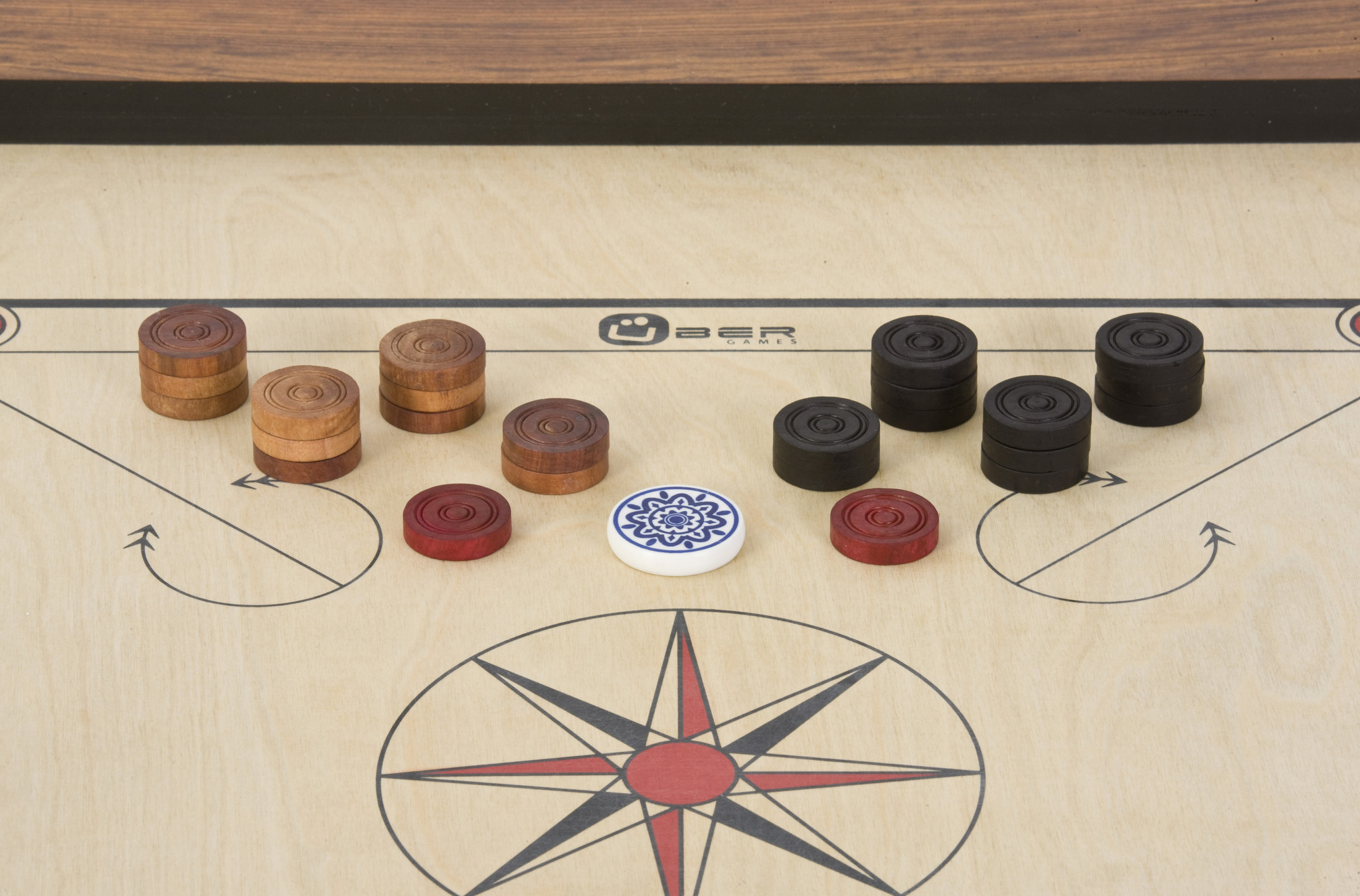 Carrom-Brett mit Holz- und schwarzen Figuren, mit einem weißen Angreifer.