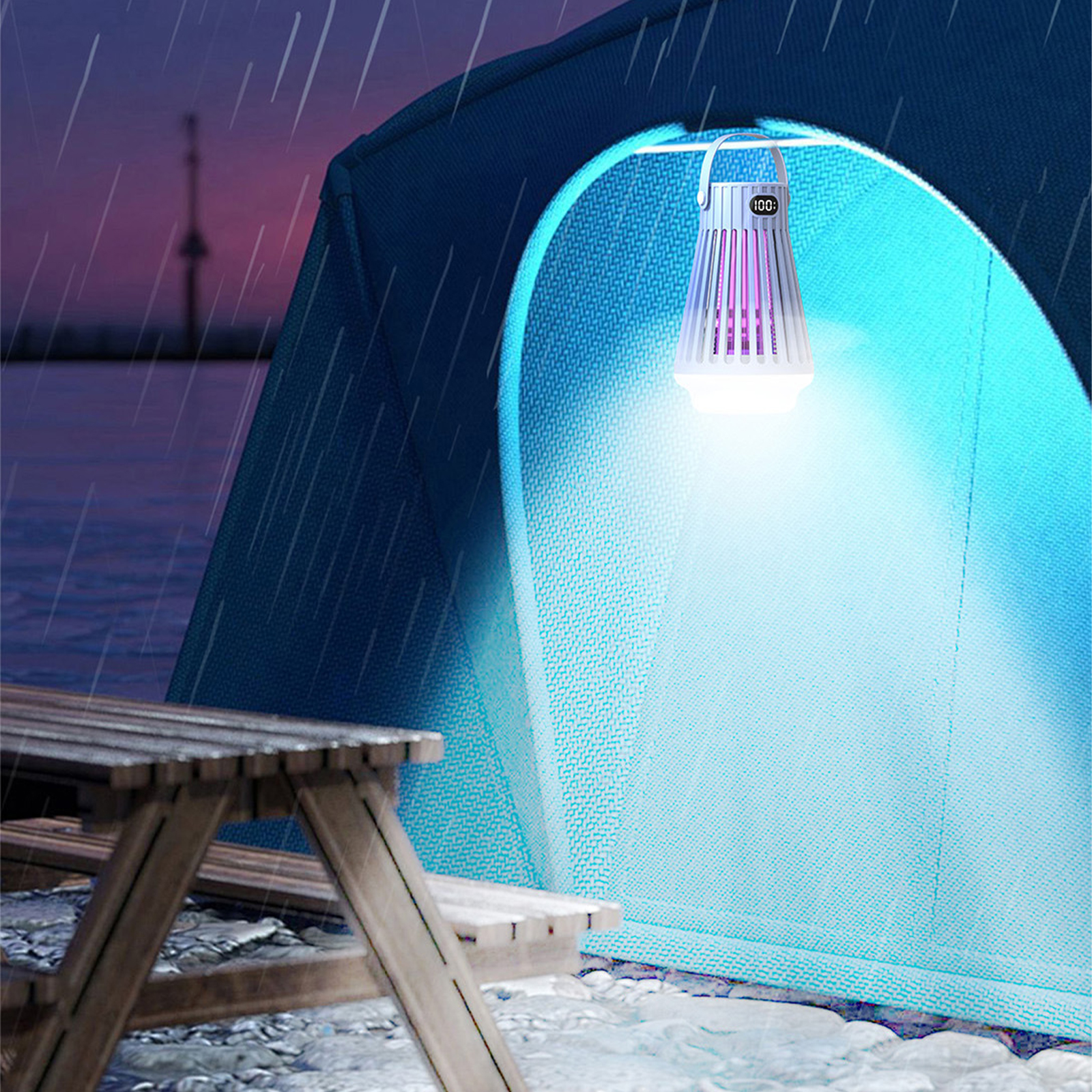Ein Zelt mit Licht im Inneren ist bei Regen an. Im Vordergrund ein Picknicktisch.