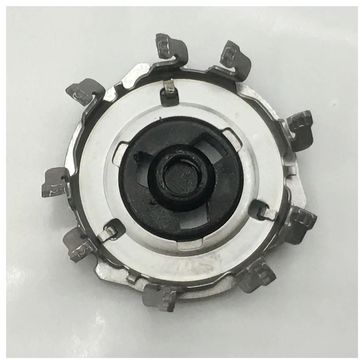 Ein Rasierkopf mit schwarzem Zentrum und silbernem Metall, mit kreisförmigem Design.