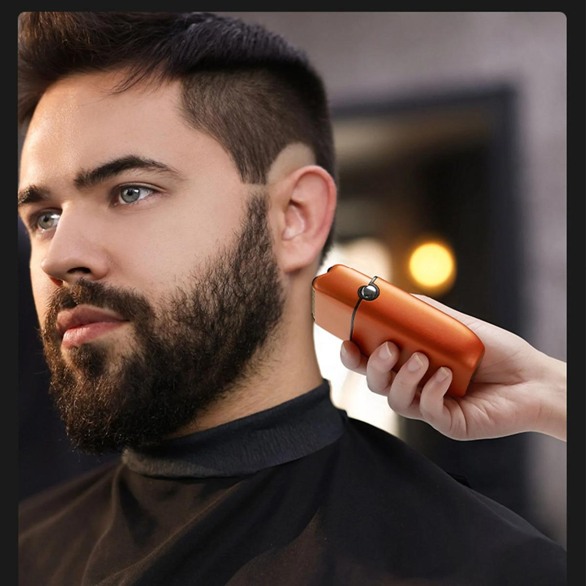 Ein Mann lässt sich seinen Bart mit einem orangenen Rasierer trimmen. Seine Hand hält den Rasierer.