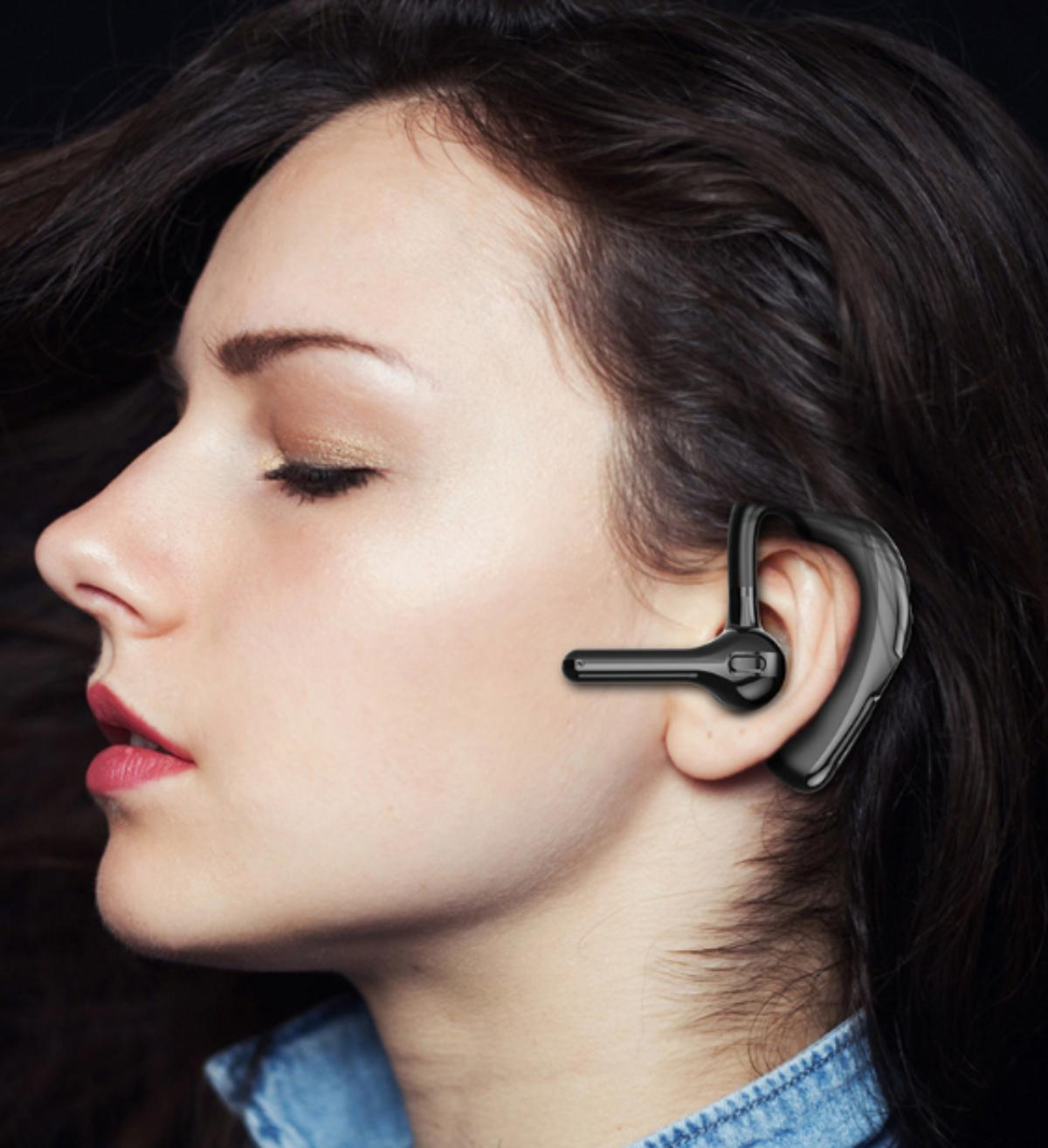 Eine Frau mit einem Bluetooth-Headset im Ohr.