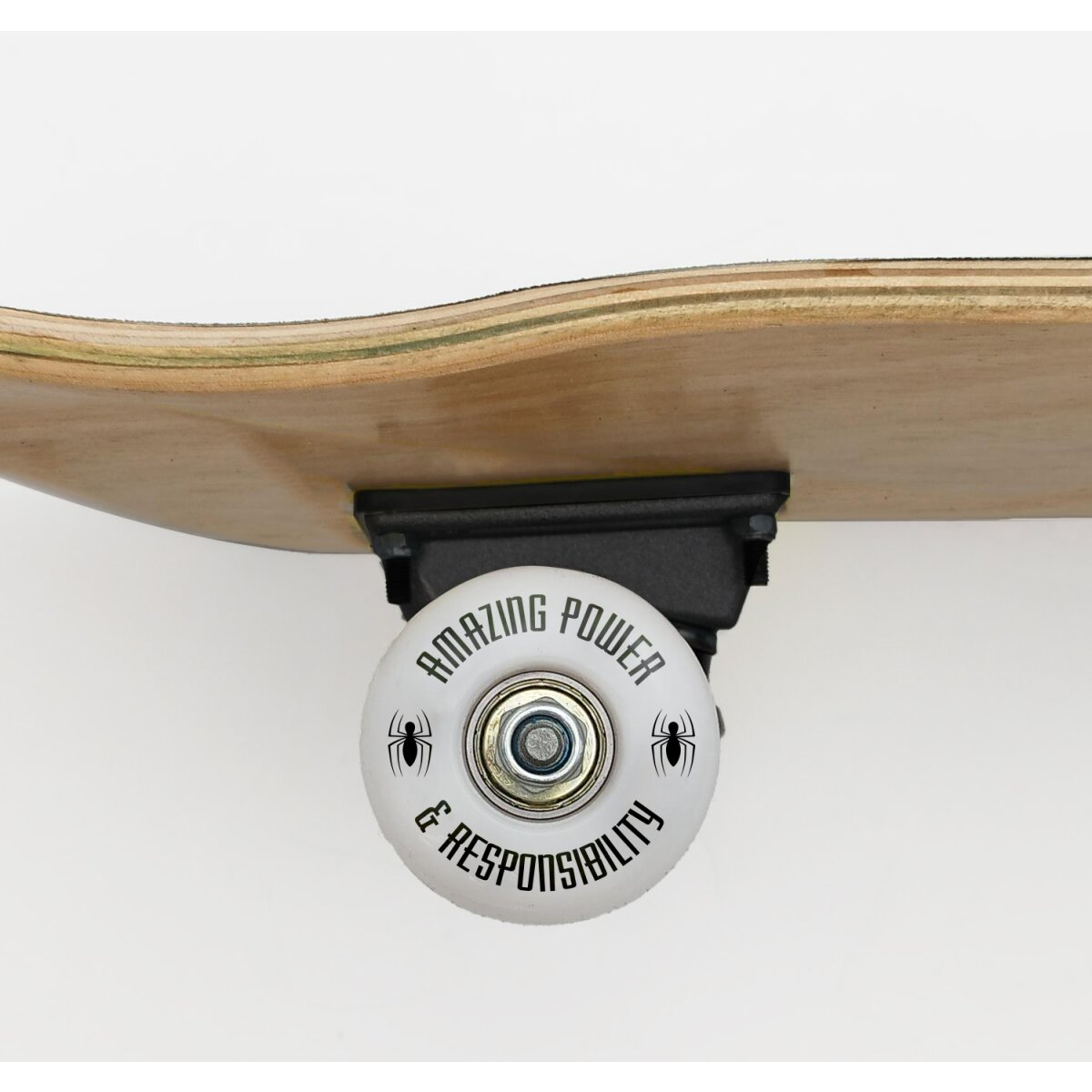 Nahaufnahme eines Skateboard-Rads mit dem Text AMAZING POWER & RESPONSIBILITY. Das Deck ist hellbraunes Holz.