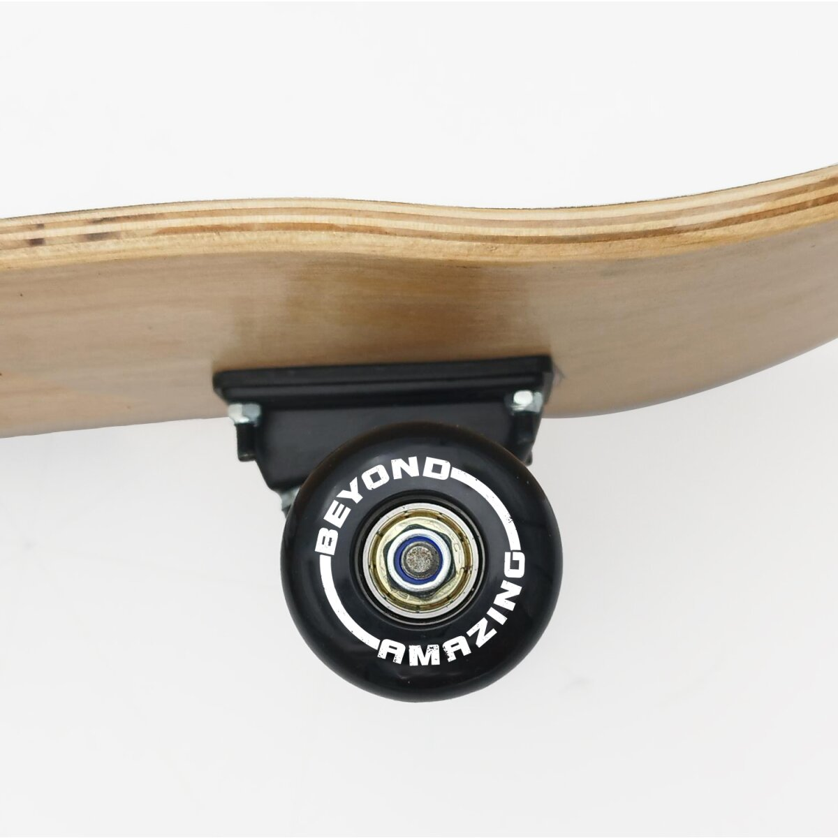 Nahaufnahme eines Skateboard-Rads mit dem Text AMAZING. Das Deck ist hellbraunes Holz.