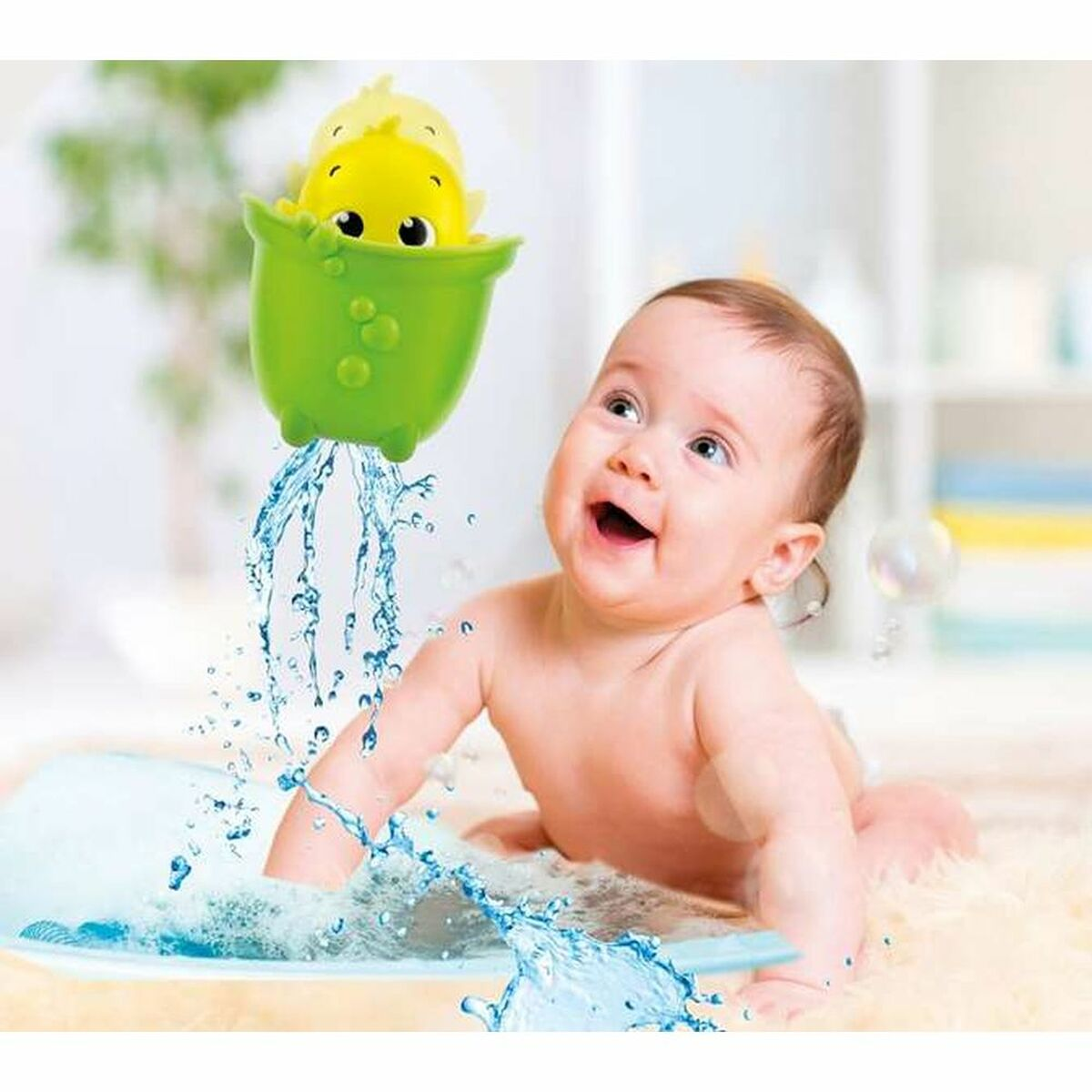 Un bebé en una bañera sonriendo, con un pato de juguete que rocía agua. El fondo es una habitación blanca.