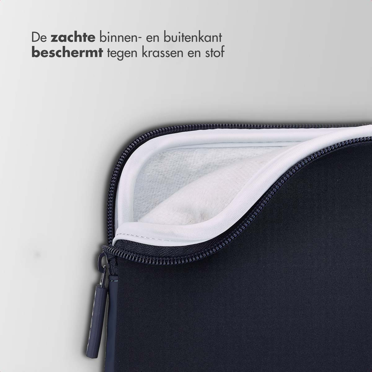 Navy laptop sleeve open, revealing white interior. Zipper and label visible.