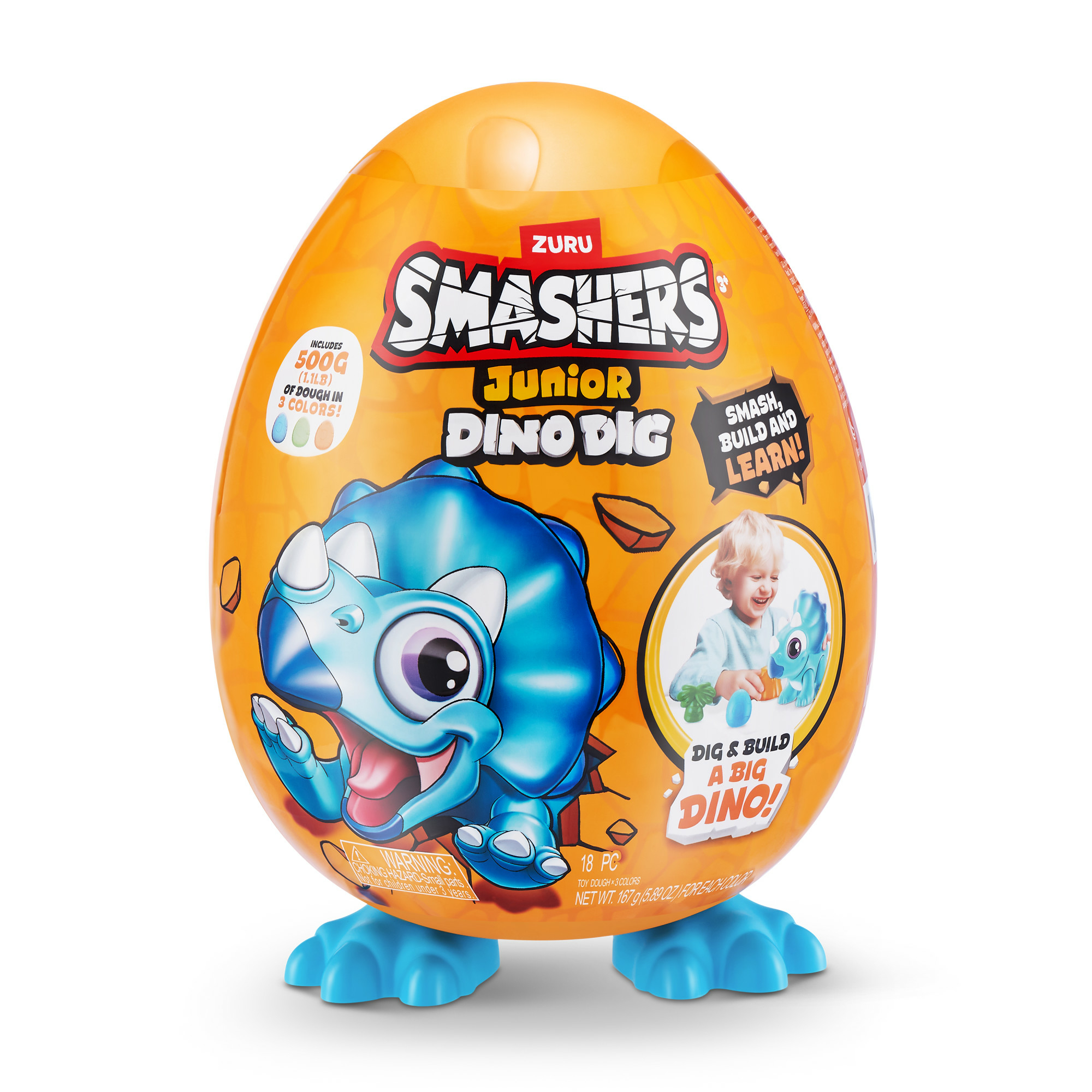 Pomarańczowa zabawka w kształcie jajka z niebieskim dinozaurem. Tekst na opakowaniu: "Smashers Junior Dino Dig".