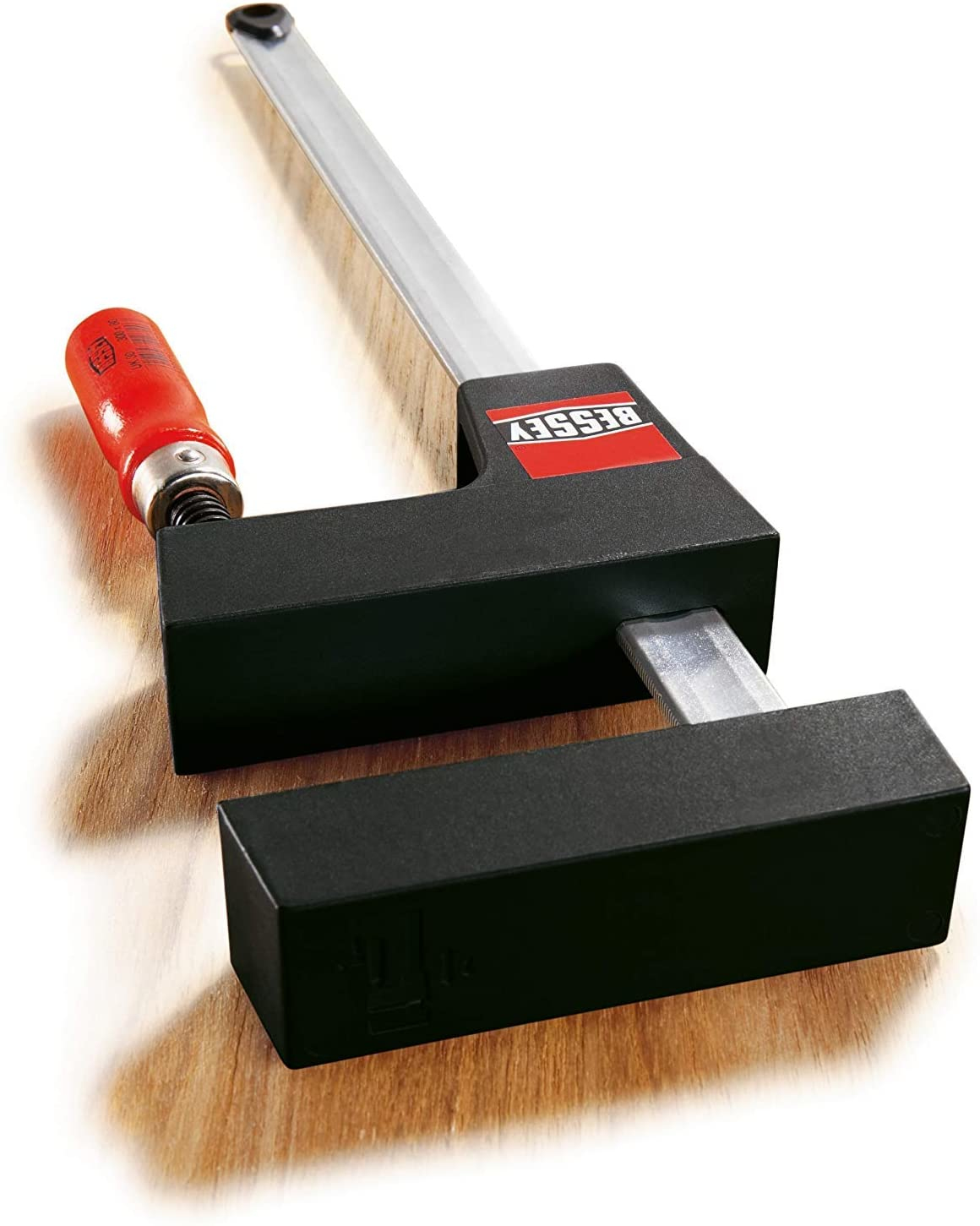 Schwarze und silberne Bessey-Klemme mit rotem Griff auf Holz. Die Klemme ist auf dem Holz angewinkelt.