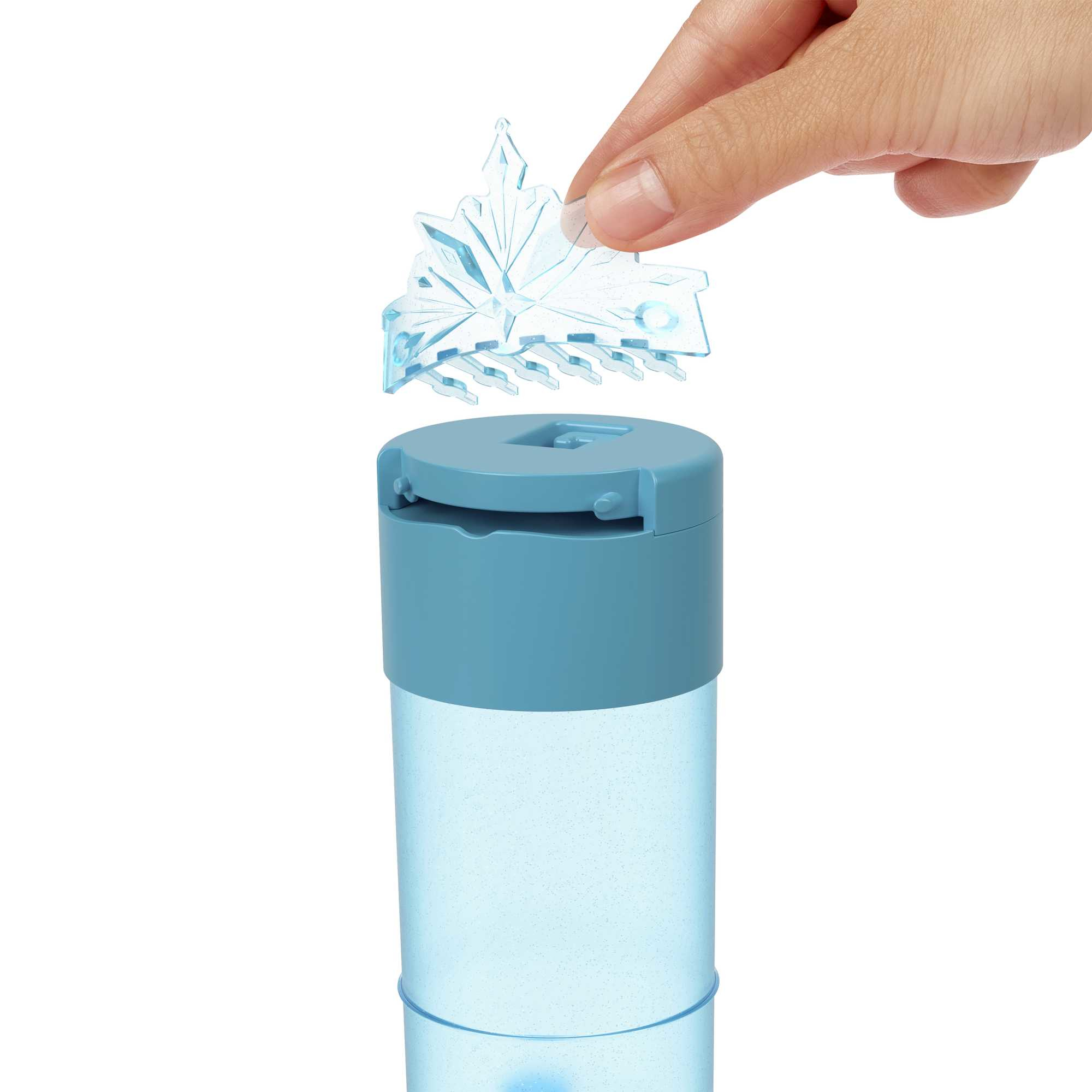 Mano che posiziona una clip a forma di fiocco di neve su un contenitore di plastica blu. Sfondo bianco.