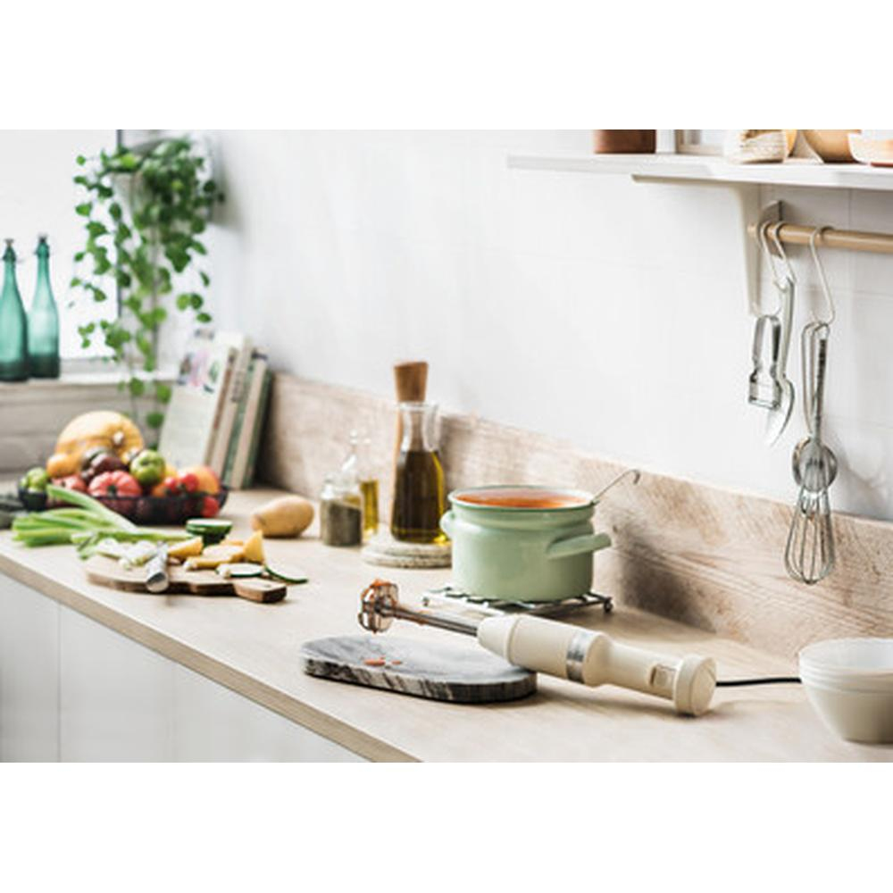 Otwarta kremowa lodówka z półkami, szufladami i schowkami w drzwiach.