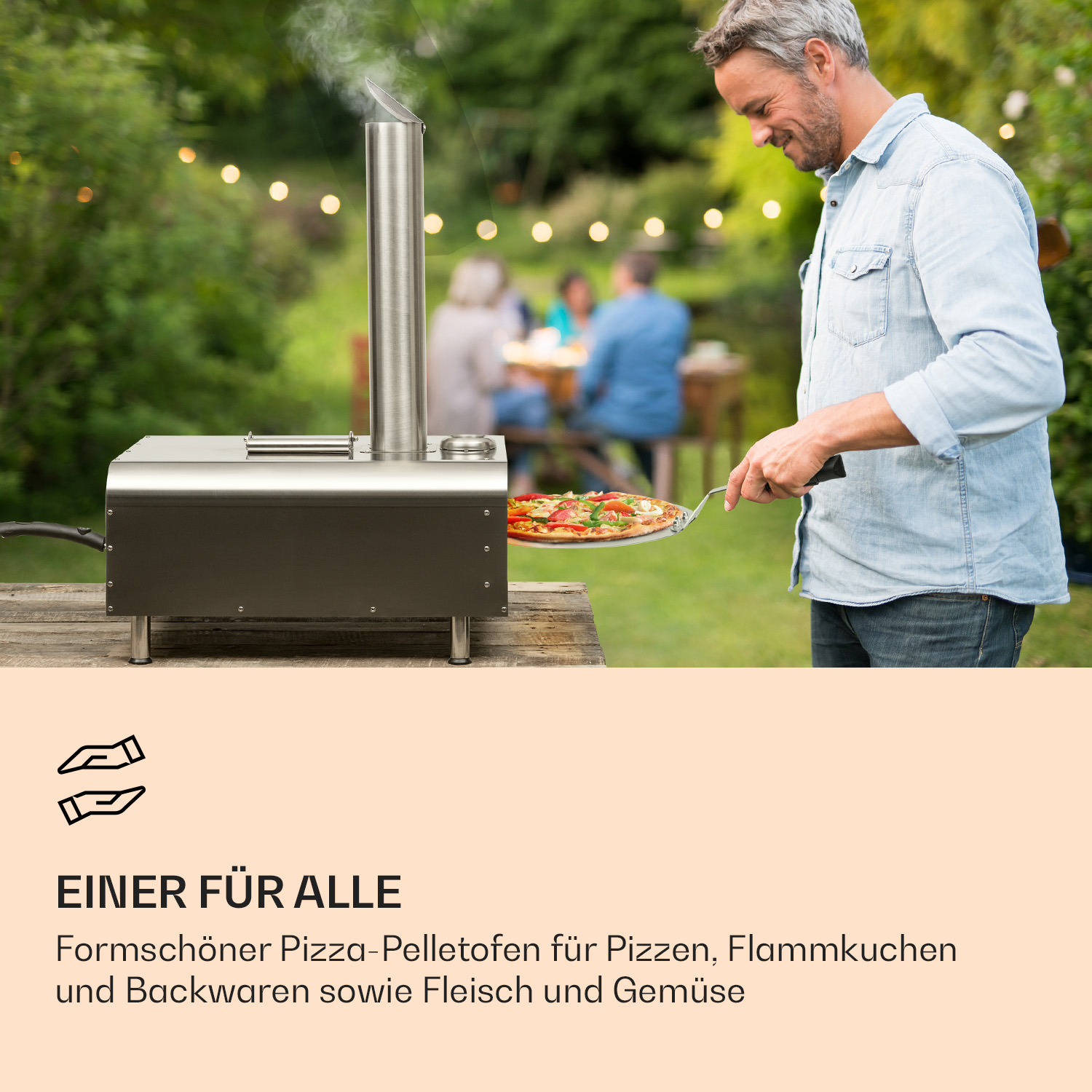 Ein Mann holt eine Pizza aus einem schwarzen Pizzaofen im Freien mit langem Griff. Leute im Hintergrund.