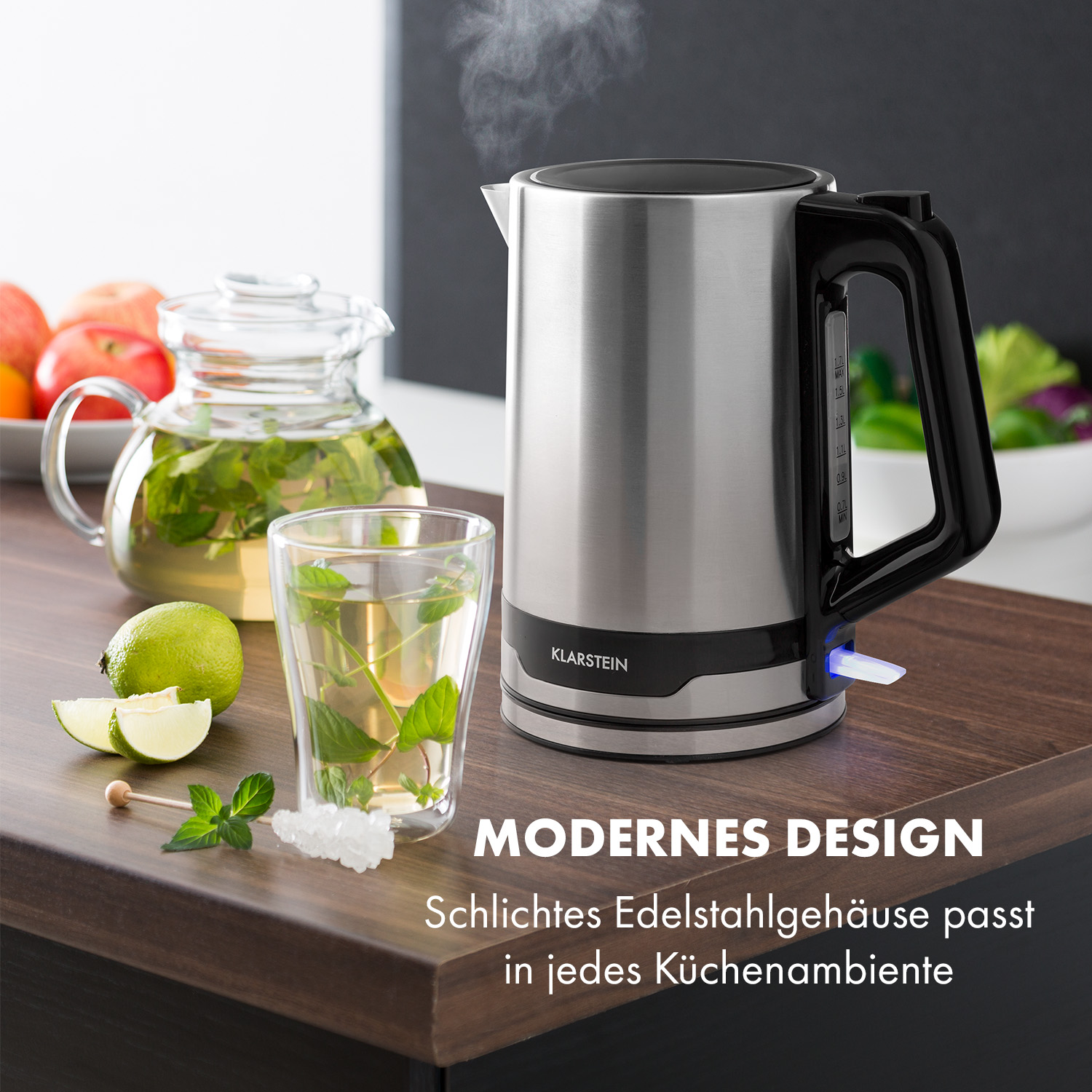 Hervidor eléctrico de acero inoxidable. Vaso de té y rodaja de lima en superficie de madera.