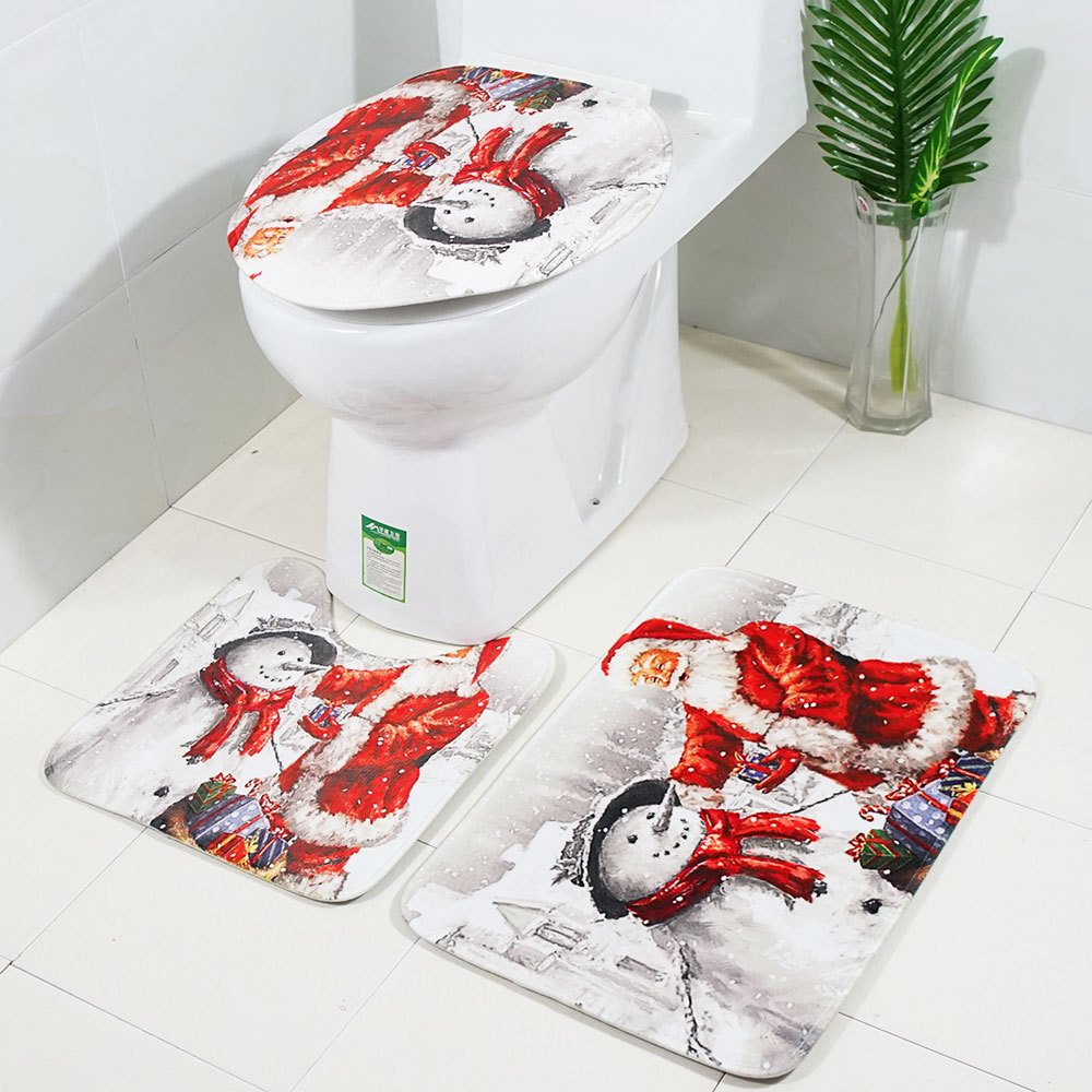 Toilette mit passendem Sitz und zwei Matten, alle mit Schneemann-Design. Weißer Fliesenboden.