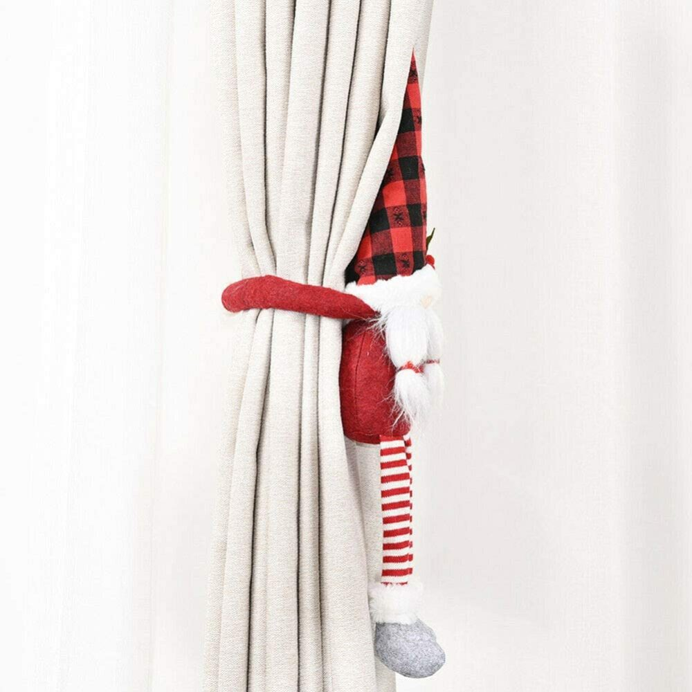 Ein rot-schwarzer Weihnachts-Wichtel-Vorhanghalter hängt an einem Vorhang.