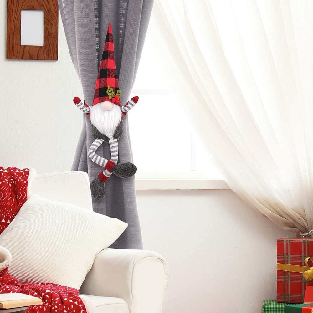Eine Weihnachtsgnom-Dekoration, die an einem Vorhang neben einem Fenster und einer weißen Couch hängt.