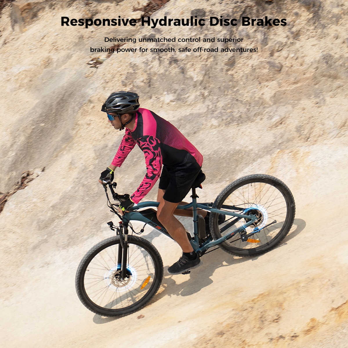E-rower pod górę. Mężczyzna w kasku i różowej koszuli. Tło: skalisty teren. Tekst: 'Reaktywne hydrauliczne hamulce tarczowe'.
