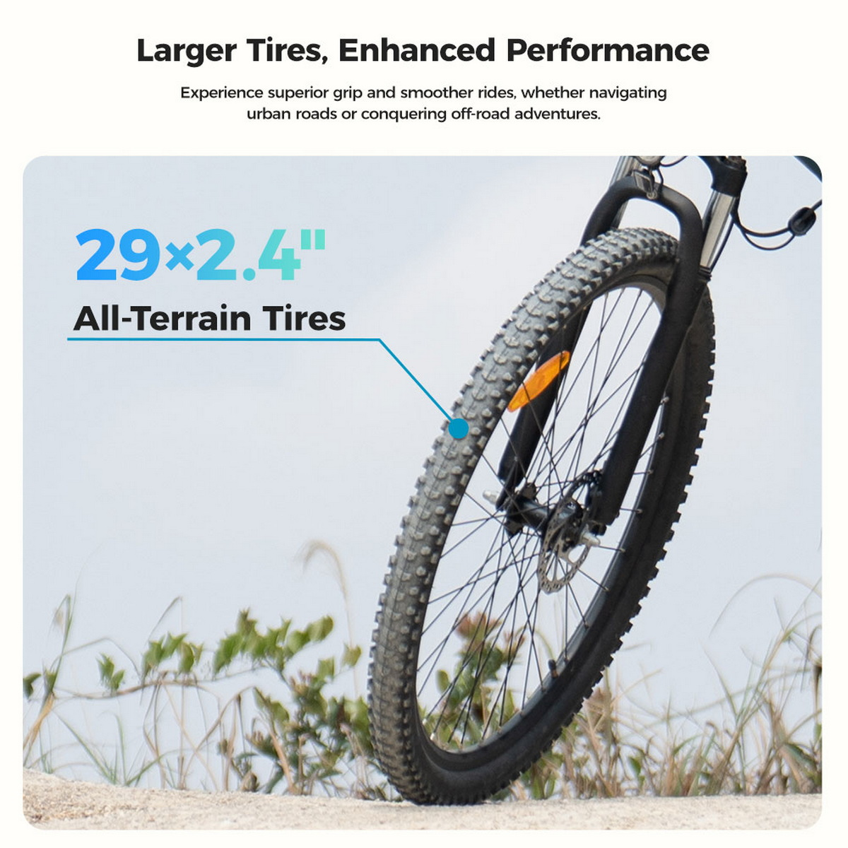 Nahaufnahme eines E-Bike-Reifens auf einem Pfad. Der Reifen ist schwarz mit Profil. Hintergrund: Himmel und Gras.