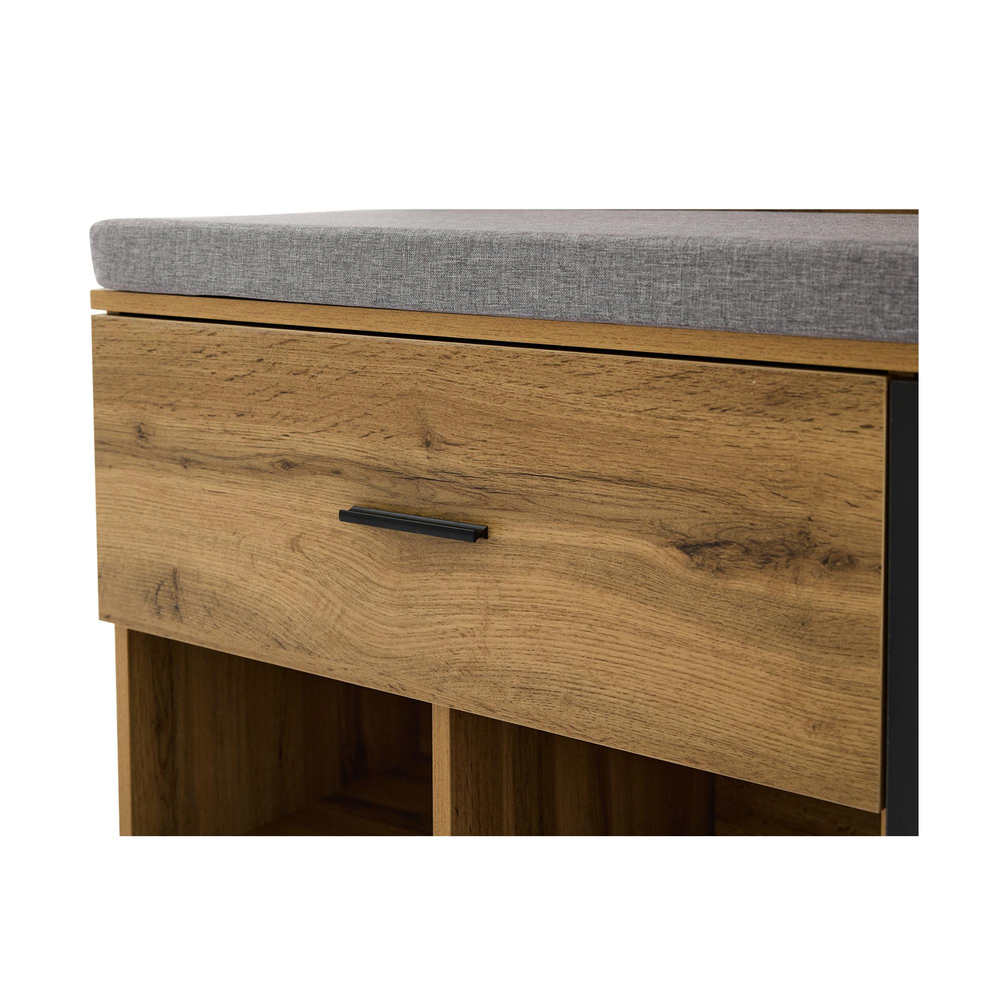 Nahaufnahme einer Holzschublade mit schwarzem Griff und grauem Kissen.