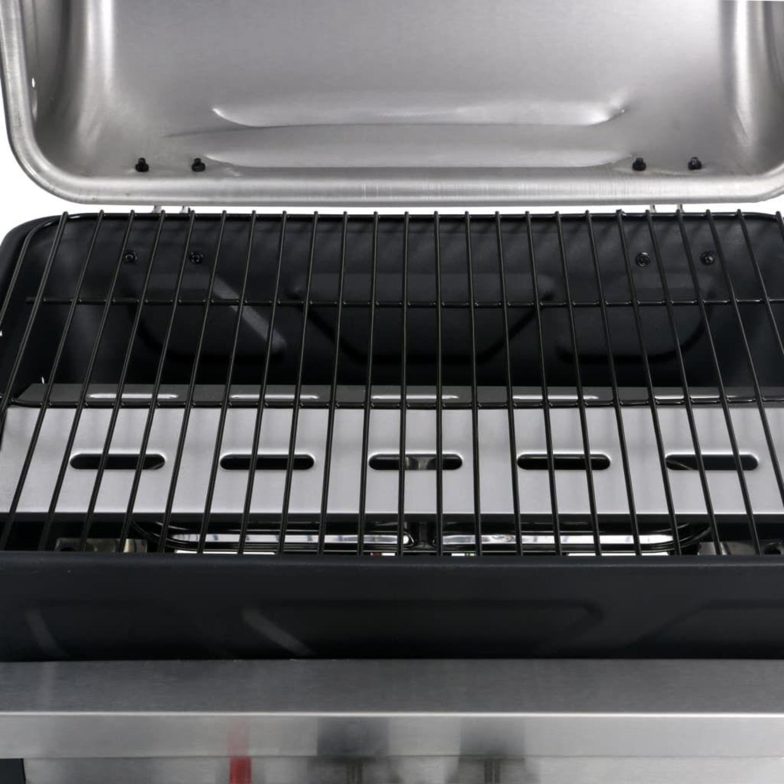 Nahaufnahme eines Grills mit schwarzem Rost und Edelstahl-Innenraum.