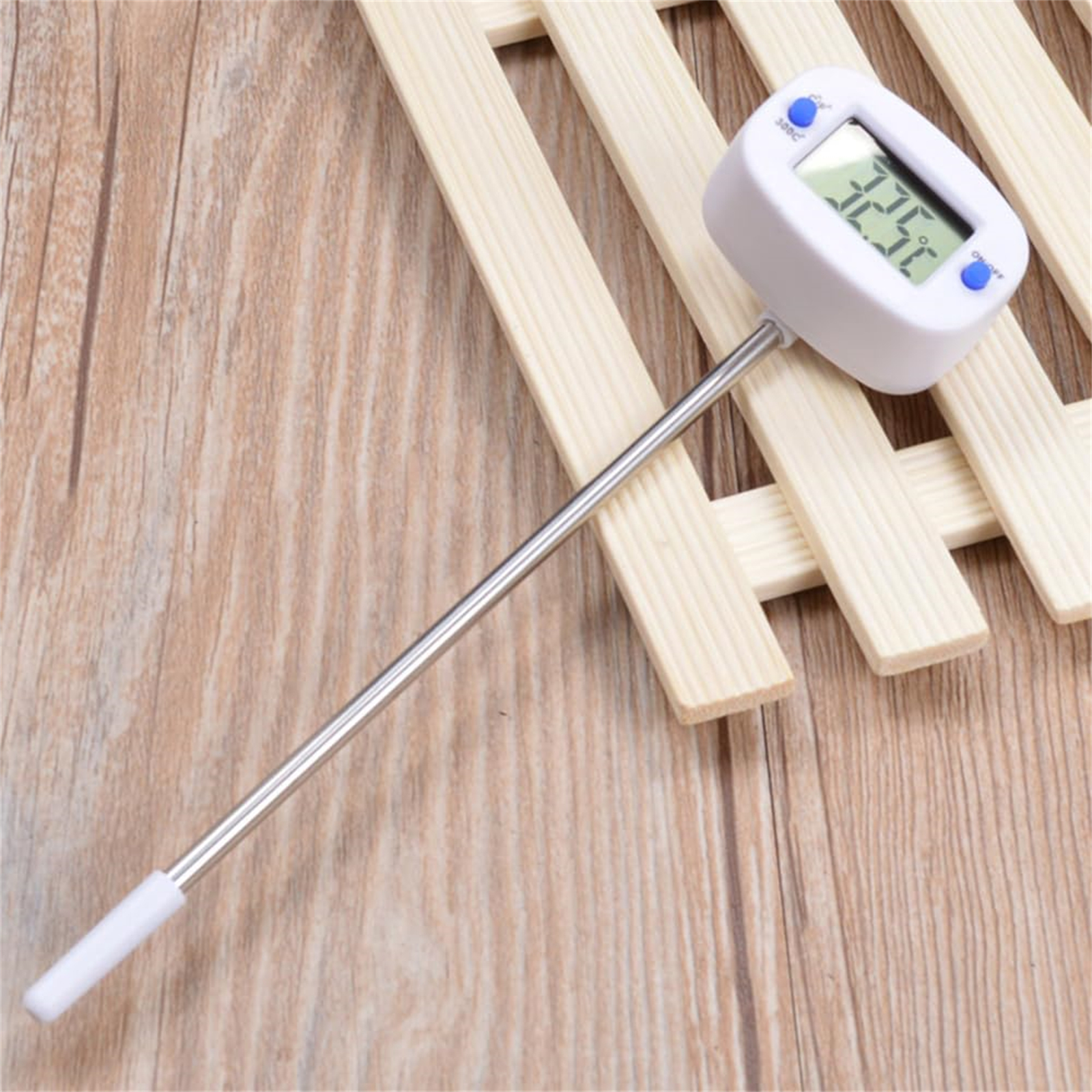 Digitales Thermometer, weiß. Zeigt 32,5 Grad an. Auf einer Holzoberfläche. Weiße Sondenspitze.