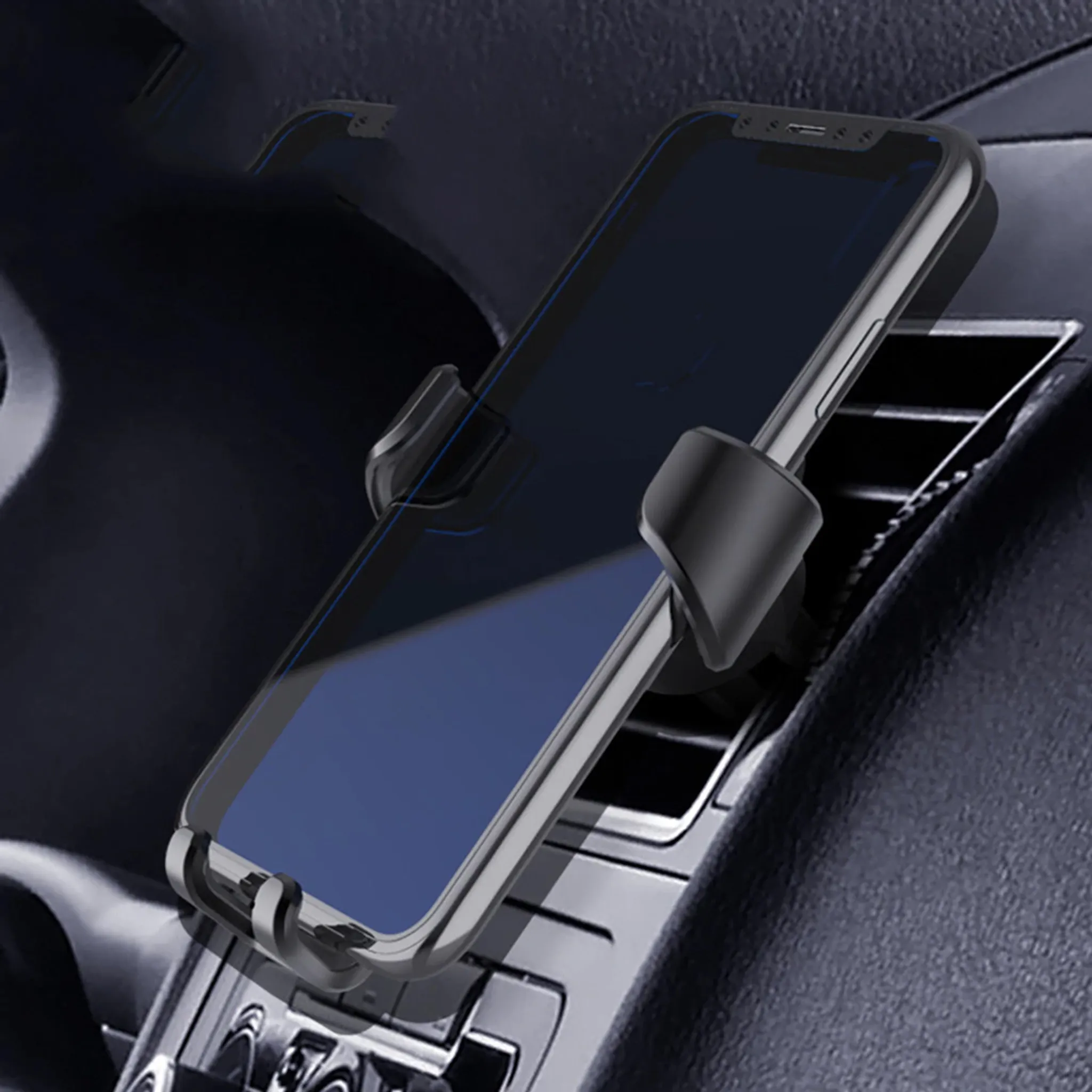 Ein Telefon befindet sich in einer Autotelefonhalterung. Das Armaturenbrett und die Lüftung sind ebenfalls sichtbar.